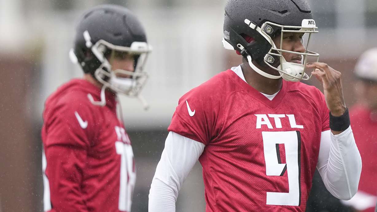 Atlanta Falcons quarterbacks Michael Penix Jr., right, and Kirk Cousins, left, run drills during an NFL football mini training camp practice on Tuesday, May 14, 2024, in Flowery Branch, Ga.