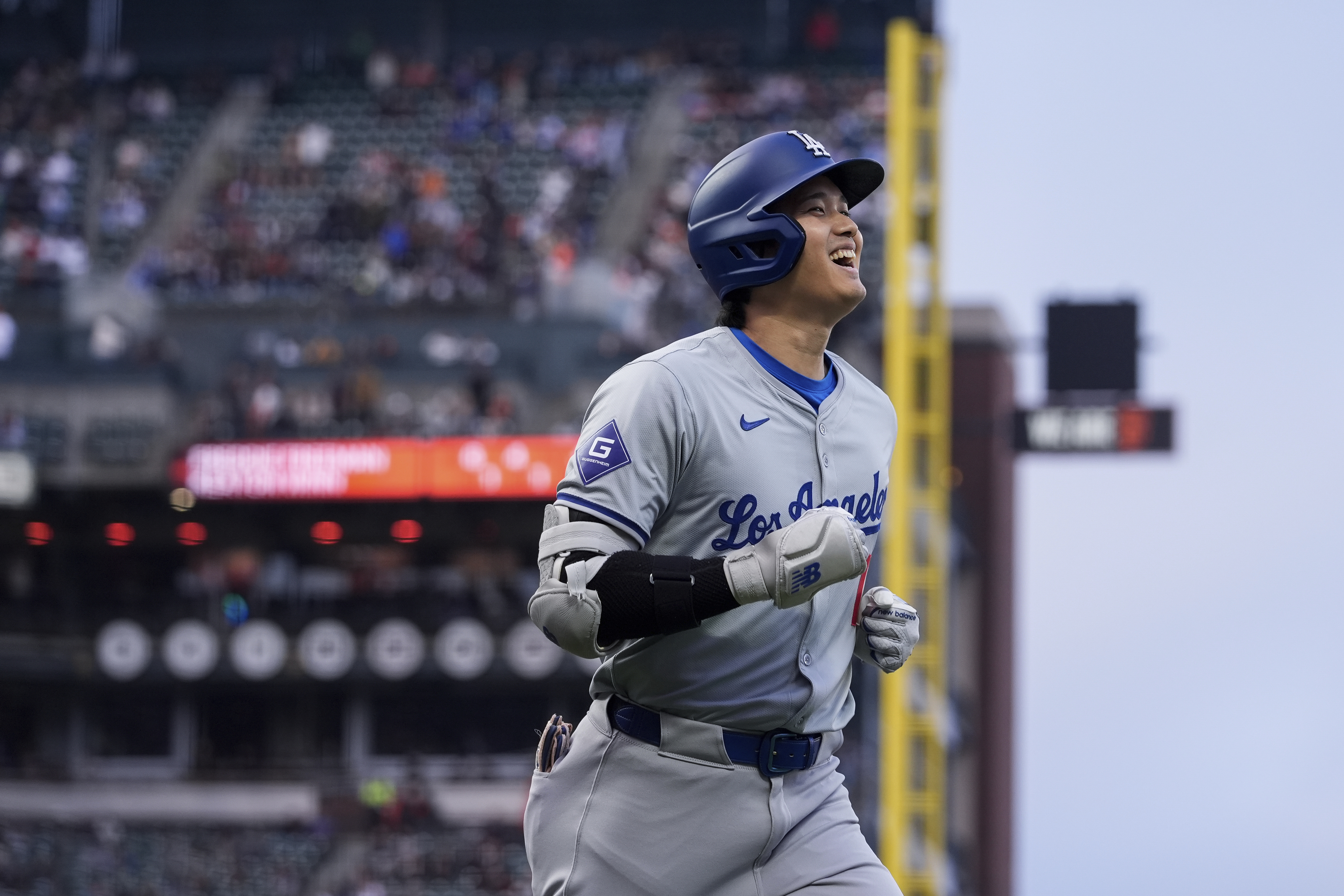 Los Angeles Dodgers' Shohei Ohtani smiles as he jogs to the dugout following his solo home run against the San Francisco Giants during the fourth inning of a baseball game Tuesday, May 14, 2024, in San Francisco. 