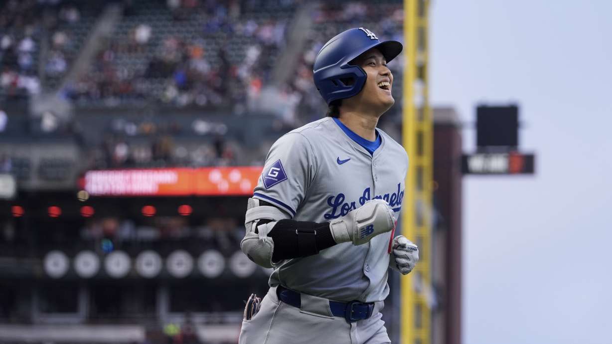 Los Angeles Dodgers' Shohei Ohtani smiles as he jogs to the dugout following his solo home run against the San Francisco Giants during the fourth inning of a baseball game Tuesday, May 14, 2024, in San Francisco.