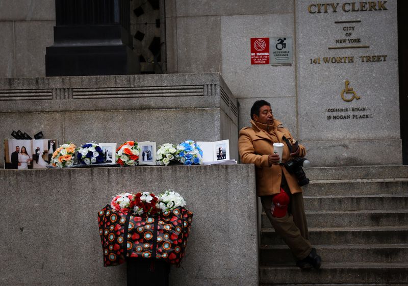 A photographer hoping to sell pictures to newlyweds waits outside the office of the New York City City Clerk in lower Manhattan, New York, March 23, 2023. U.S. consumer prices increased less than expected in April, the government said Wednesday.