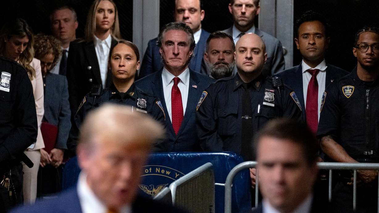 Supporters of former President Donald Trump, including North Dakota Gov. Doug Burgum, center, Rep. Cory Mills, R-Fla., center right and businessman Vivek Ramaswamy, second from right, listen as Trump speaks, Tuesday, in New York.