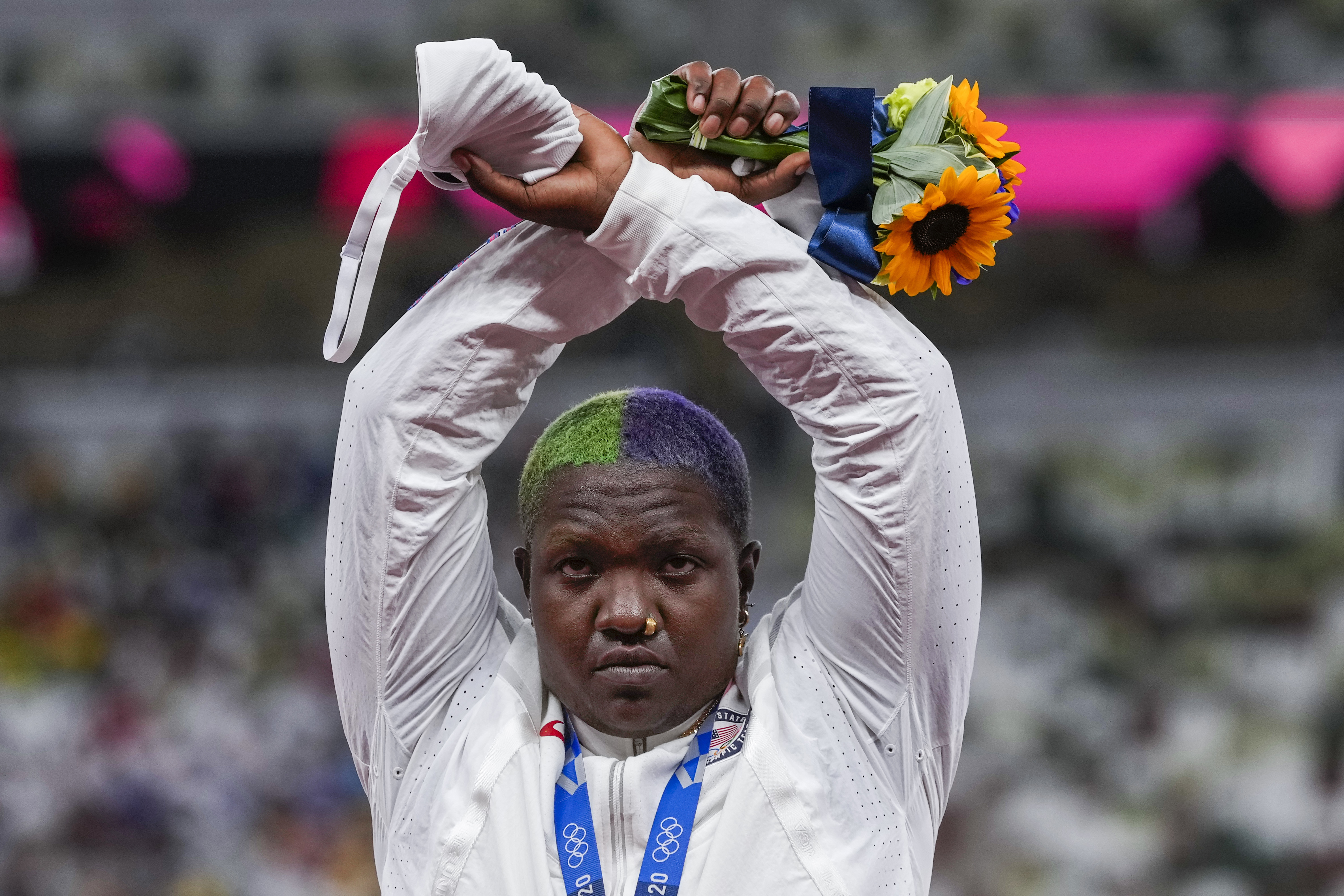 FILE -Raven Saunders, of the United States, poses with her silver medal on women's shot put at the 2020 Summer Olympics, Sunday, Aug. 1, 2021, in Tokyo, Japan. FIFA will urge all 211 national federations to mandate racist abuse in soccer as a disciplinary offense. Soccer’s world body also suggests “a global standard gesture for players to communicate racist incidents” to referees. It's hands crossed at the wrists and raised in the air.