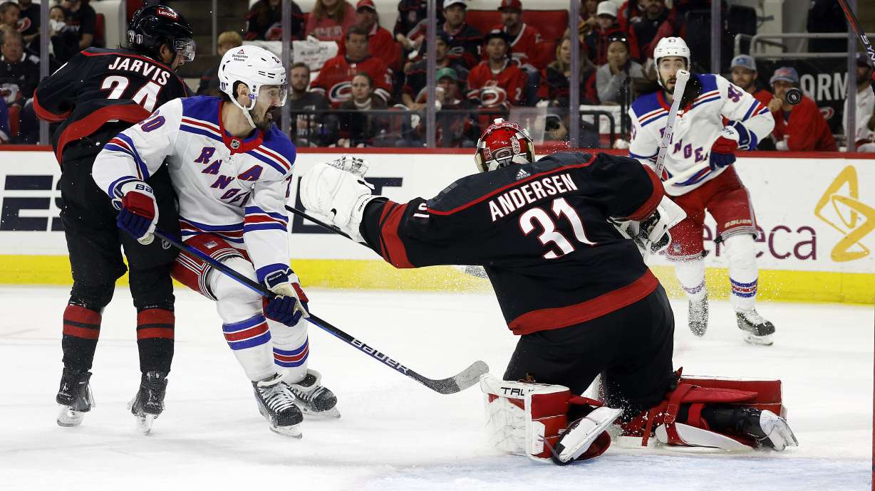 Carolina Hurricanes' Frederik Andersen (31) blocks the shot of New York Rangers' Mika Zibanejad, right rear, as Chris Kreider (20) waits for a rebound with Hurricanes' Seth Jarvis (24) nearby during the first period in Game 6 of an NHL hockey Stanley Cup second-round playoff series in Raleigh, N.C., Thursday, May 16, 2024.