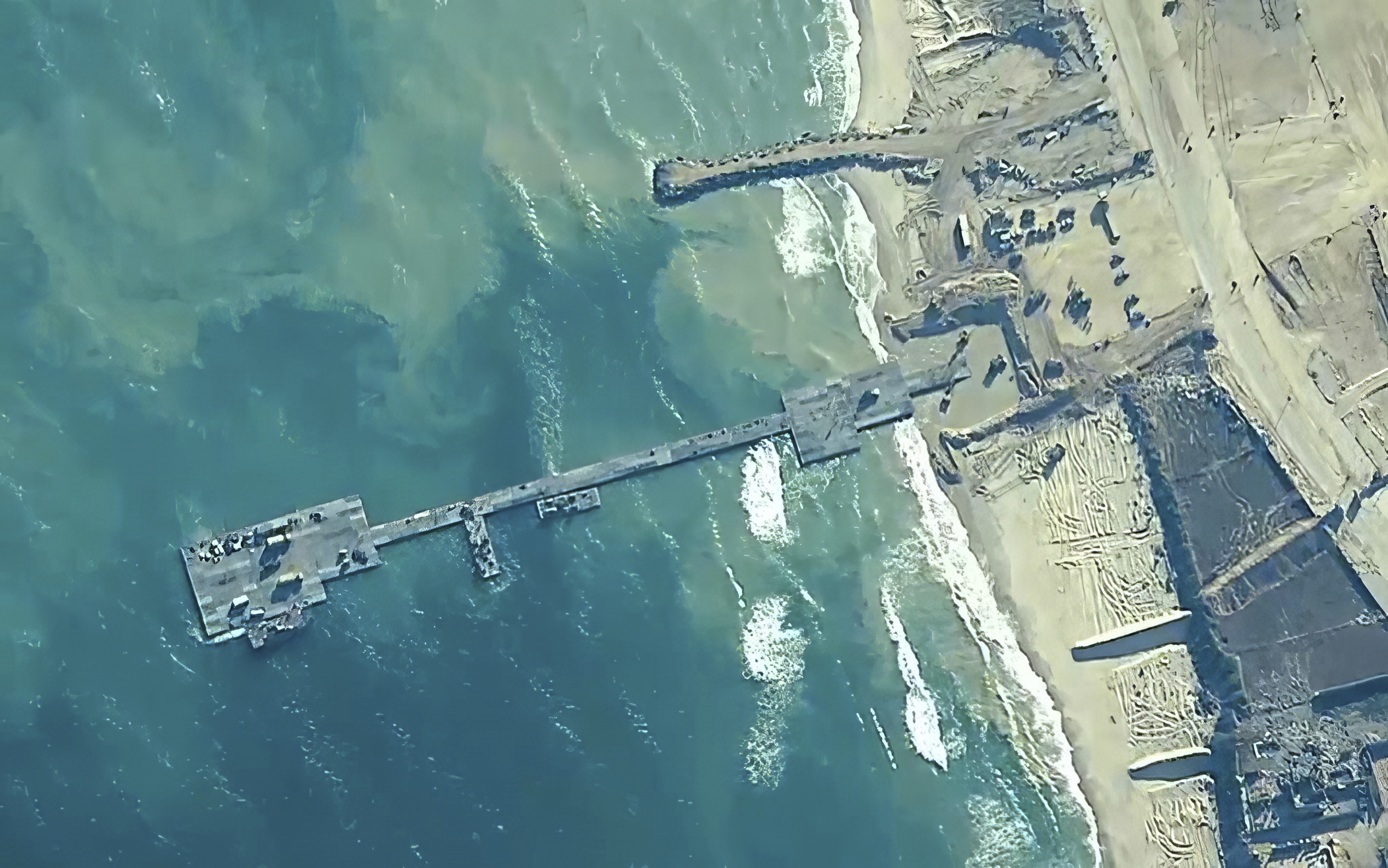 The image provided by U.S. Central Command, shows U.S. Army soldiers assigned to the 7th Transportation Brigade (Expeditionary), U.S. Navy sailors assigned to Amphibious Construction Battalion 1, and Israel Defense Forces placing the Trident Pier on the coast of Gaza Strip on Thursday.