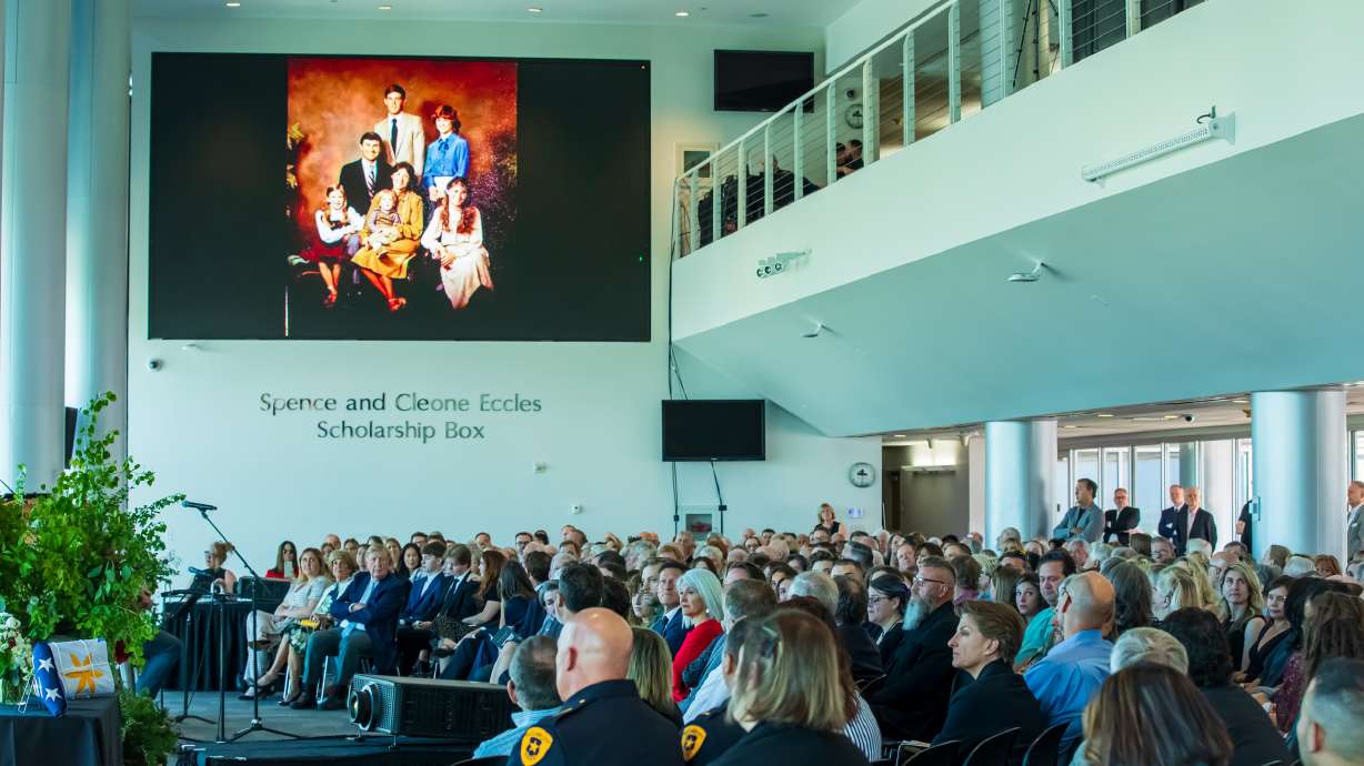 Friends, family and acquaintances of Ted Wilson watch a slideshow as his son, Joey, performs music during a public memorial service for the former Salt Lake City mayor at Rice-Eccles Stadium on Friday. Wilson died April 11 at the age of 84.