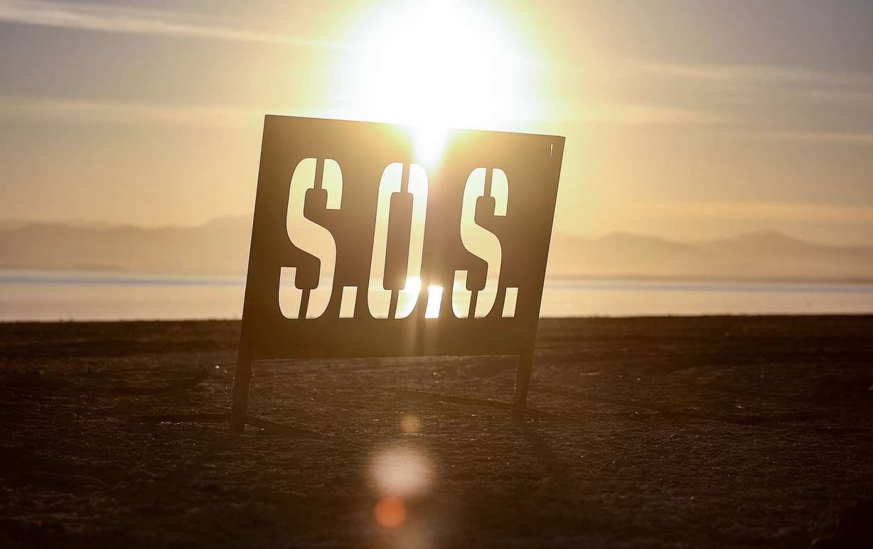 A metal SOS sign is photographed on the receding Salton Sea shoreline in Bombay Beach, California, on December 15, 2023.