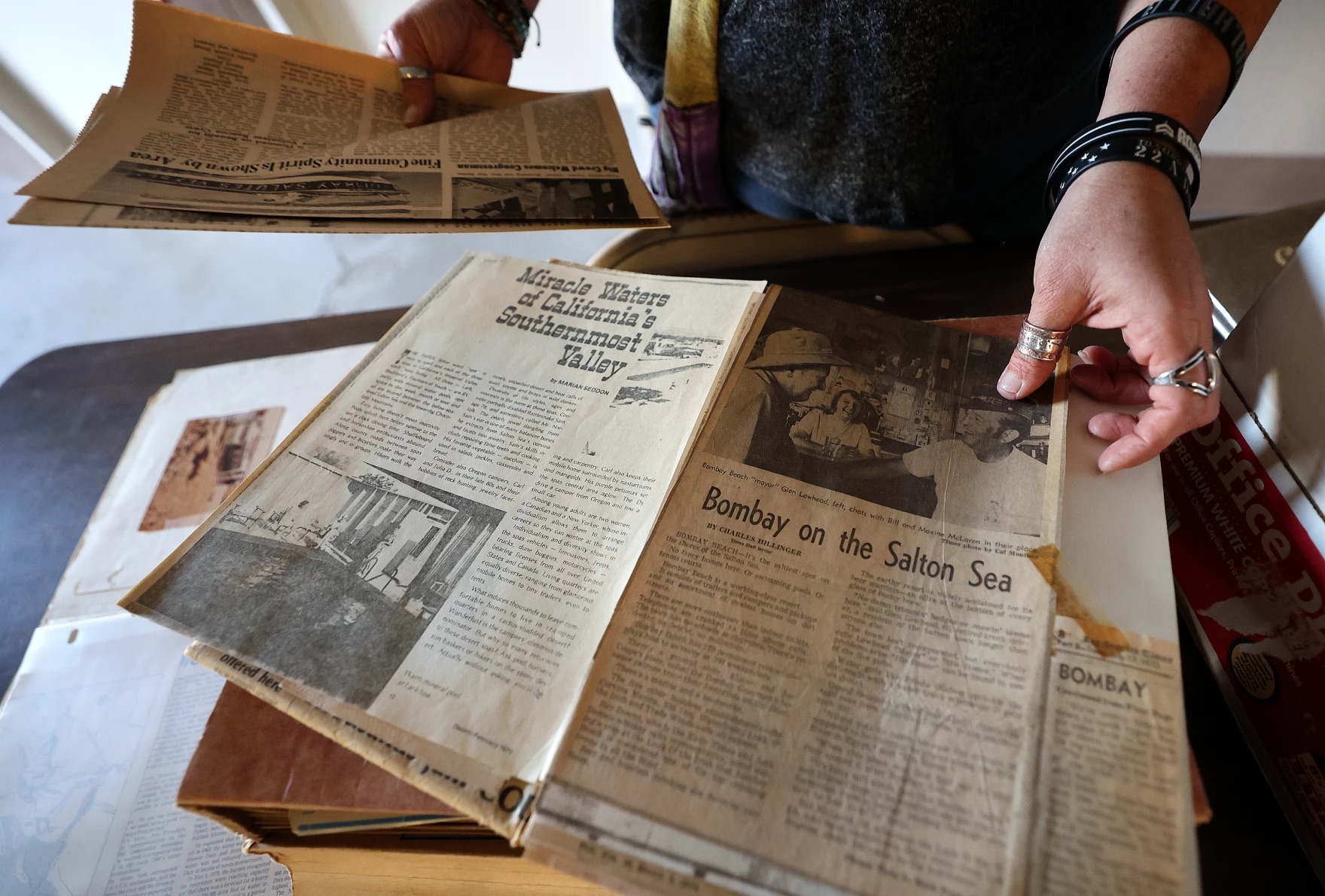 Candace Youngberg shows historic newspaper clippings about Bombay Beach in Bombay Beach, Calif., on Dec. 15, 2023.