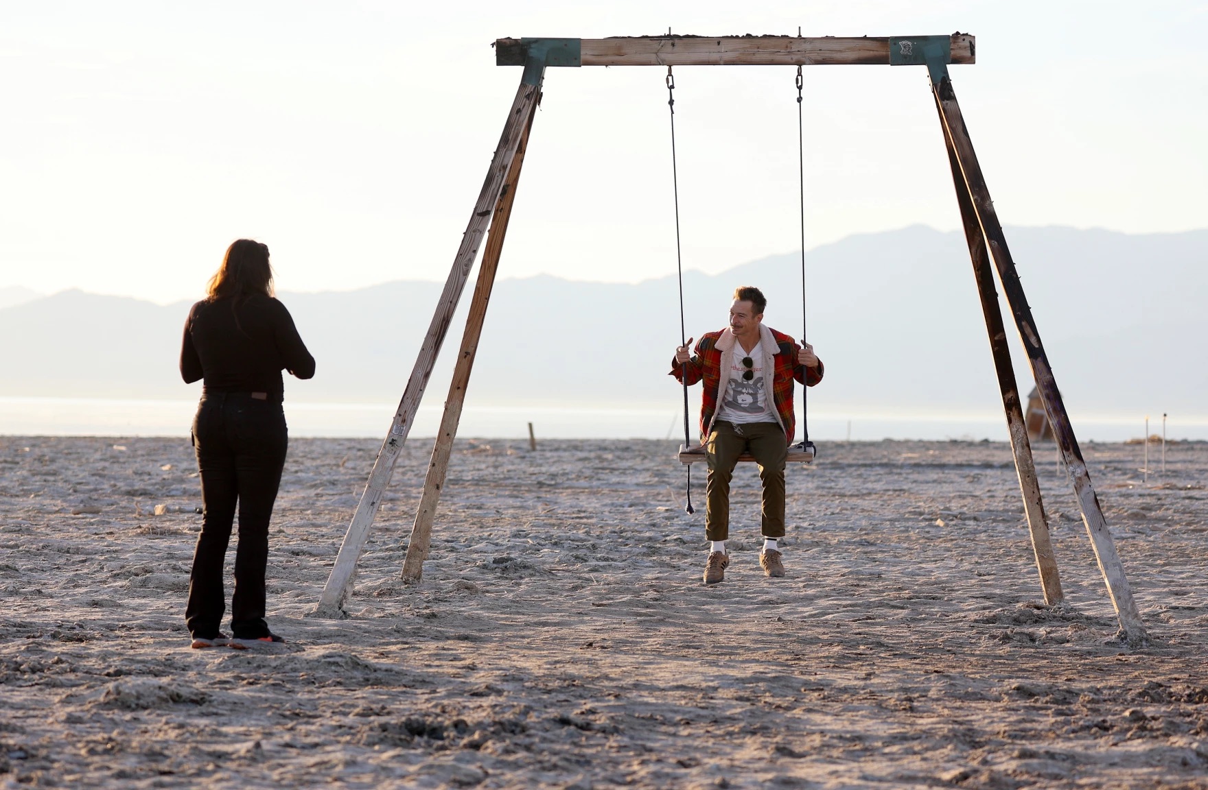 Michael Schilawski swings on a wooden swing that used to be partially submerged in water before the shoreline of the Salton Sea receded in Bombay Beach, Calif., on Dec. 14, 2023.