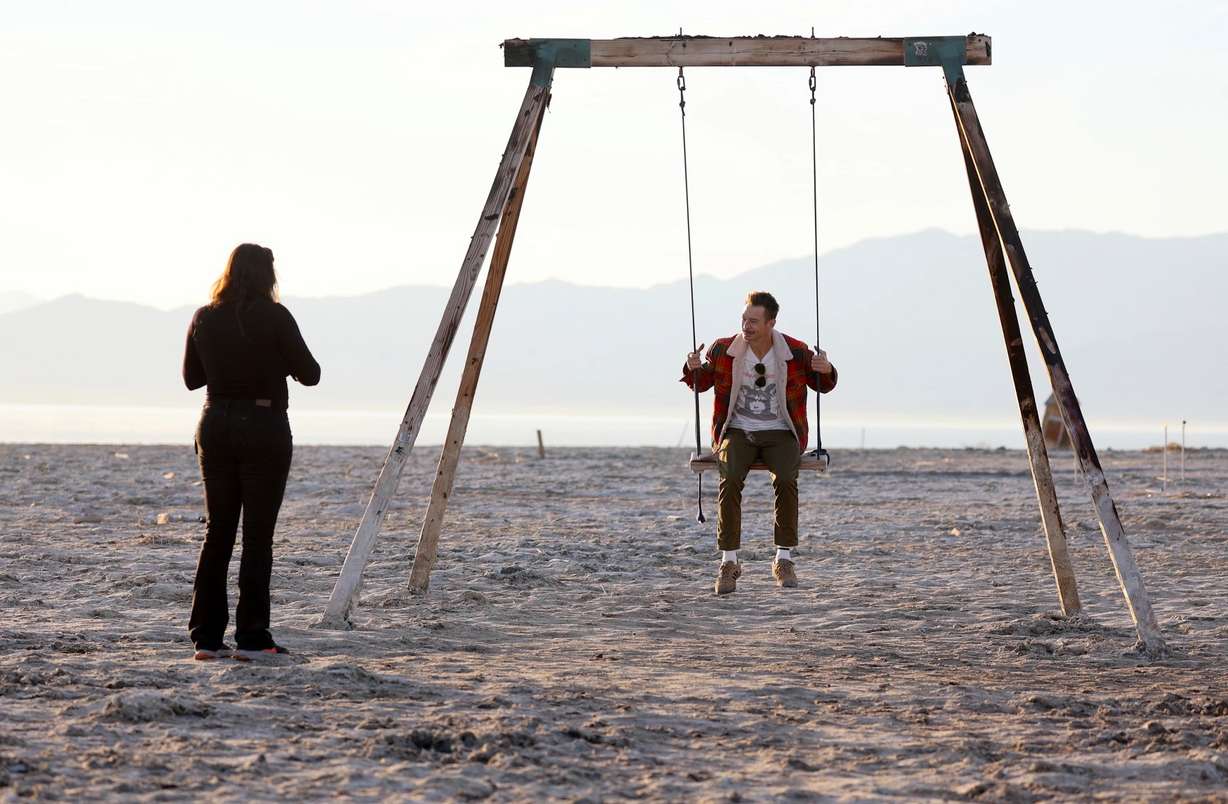 Michael Silowski rides on a wooden swing that was partially submerged in water before the Salton Sea coastline receded on December 14, 2023 in Bombay Beach, California.
