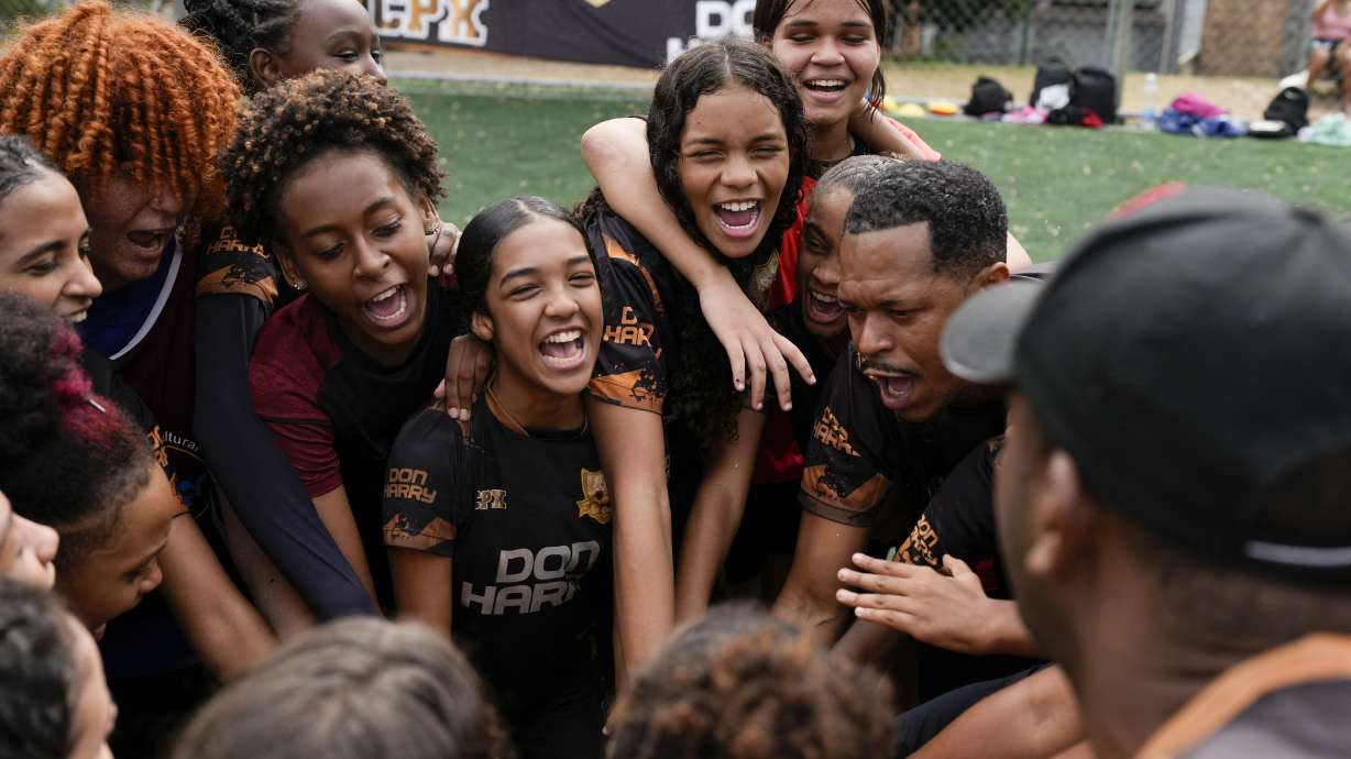 Young women and their coach Dioguinho bring it in for a team huddle at the start of a soccer training session run by the Bola de Ouro social program, at the Complexo da Alemao favela in Rio de Janeiro, Brazil, May 16, 2024. Young women are participating in soccer programs led by community trainers, where they receive both sports and personal development training.