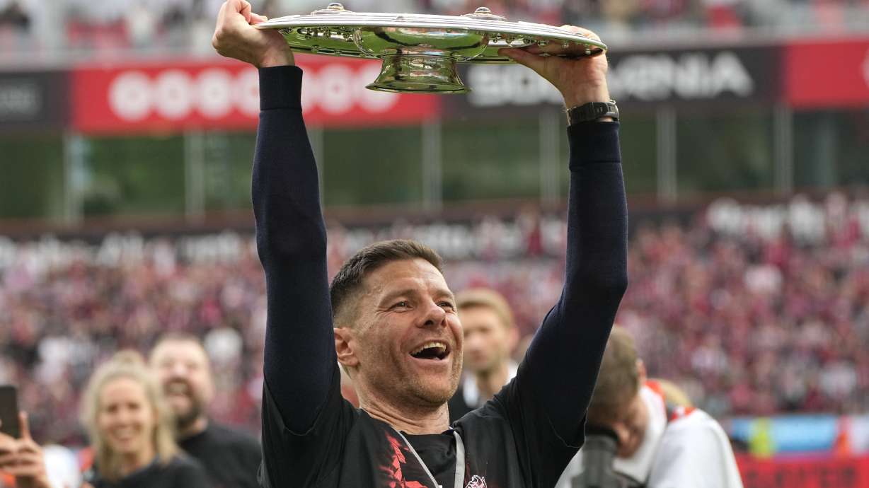 Leverkusen's head coach Xabi Alonso celebrates with the trophy as his team won the German Bundesliga, after the German Bundesliga soccer match between Bayer Leverkusen and FC Augsburg at the BayArena in Leverkusen, Germany, Saturday, May 18, 2024. Bayer Leverkusen have won the Bundesliga title for the first time. It is the first team in Bundesliga history, that won the championship unbeaten for the whole season.