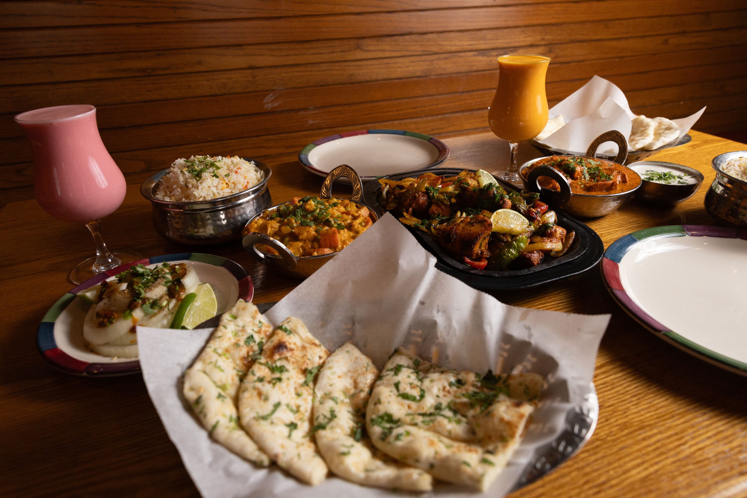 An arrangement of dishes, including naan, rice, lassis, raita, different curries and a tandoori dish, are set out for a photo at Mumbai House in Salt Lake City on Tuesday. Utah’s Indian food scene took shape 30 years ago, and is better than ever.