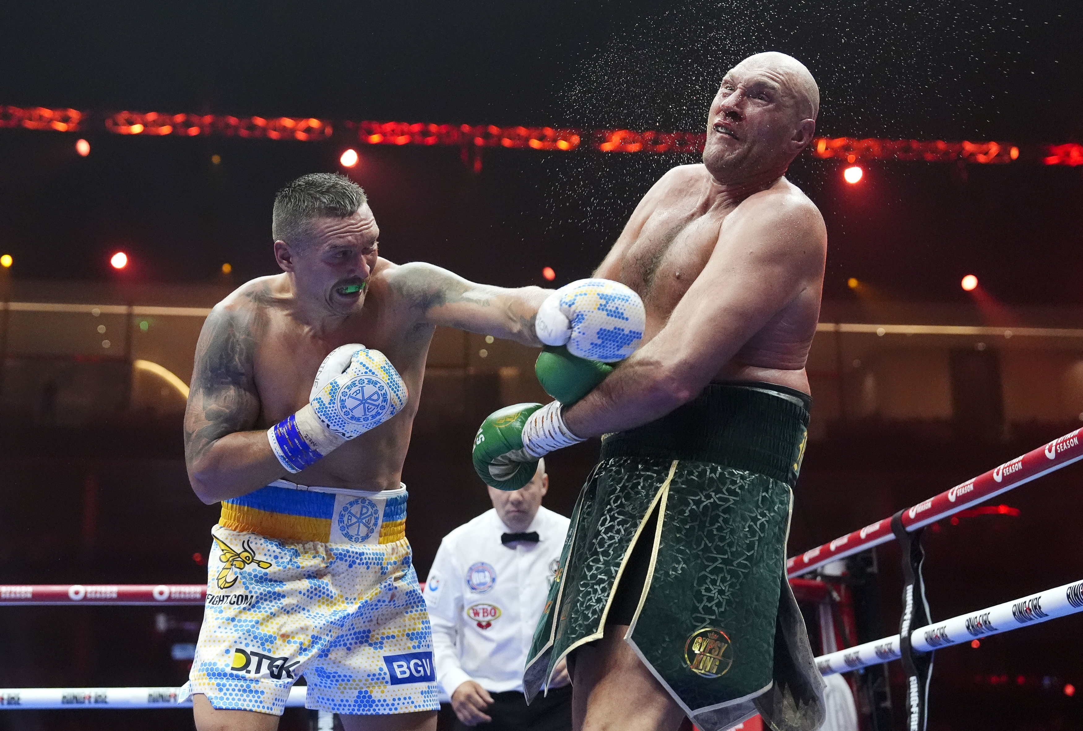Britain’s Tyson Fury, right, takes a blow from Ukraine’s Oleksandr Usyk during their undisputed heavyweight world championship boxing fight at the Kingdom Arena in Riyadh, Saudi Arabia, Sunday, May 19, 2024. 