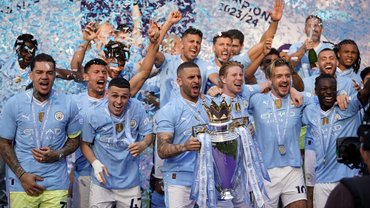 Manchester City's Kyle Walker celebrates with the Premier League trophy after the English Premier League soccer match between Manchester City and West Ham United at the Etihad Stadium in Manchester, England, Sunday, May 19, 2024. Manchester City clinched the English Premier League on Sunday after beating West Ham in their last match of the season.