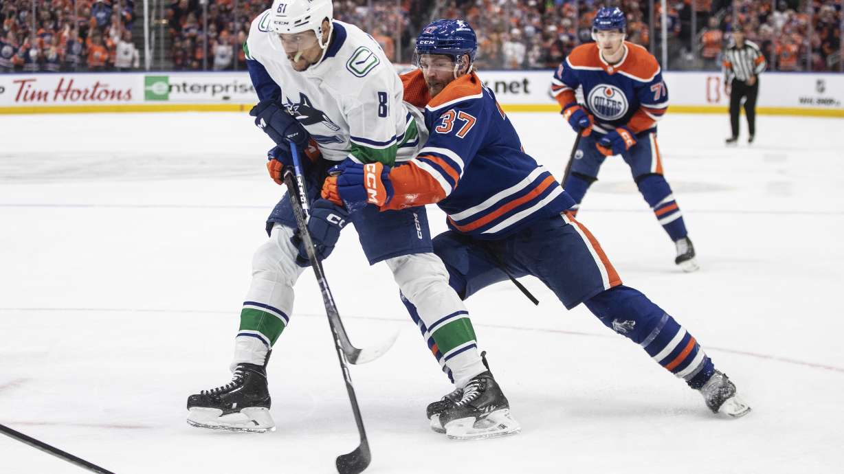 Vancouver Canucks' Dakota Joshua (81) is defended by Edmonton Oilers' Warren Foegele (37) during the third period of Game 6 of an NHL hockey Stanley Cup second-round playoff series, Saturday, May 18, 2024, in Edmonton, Alberta.