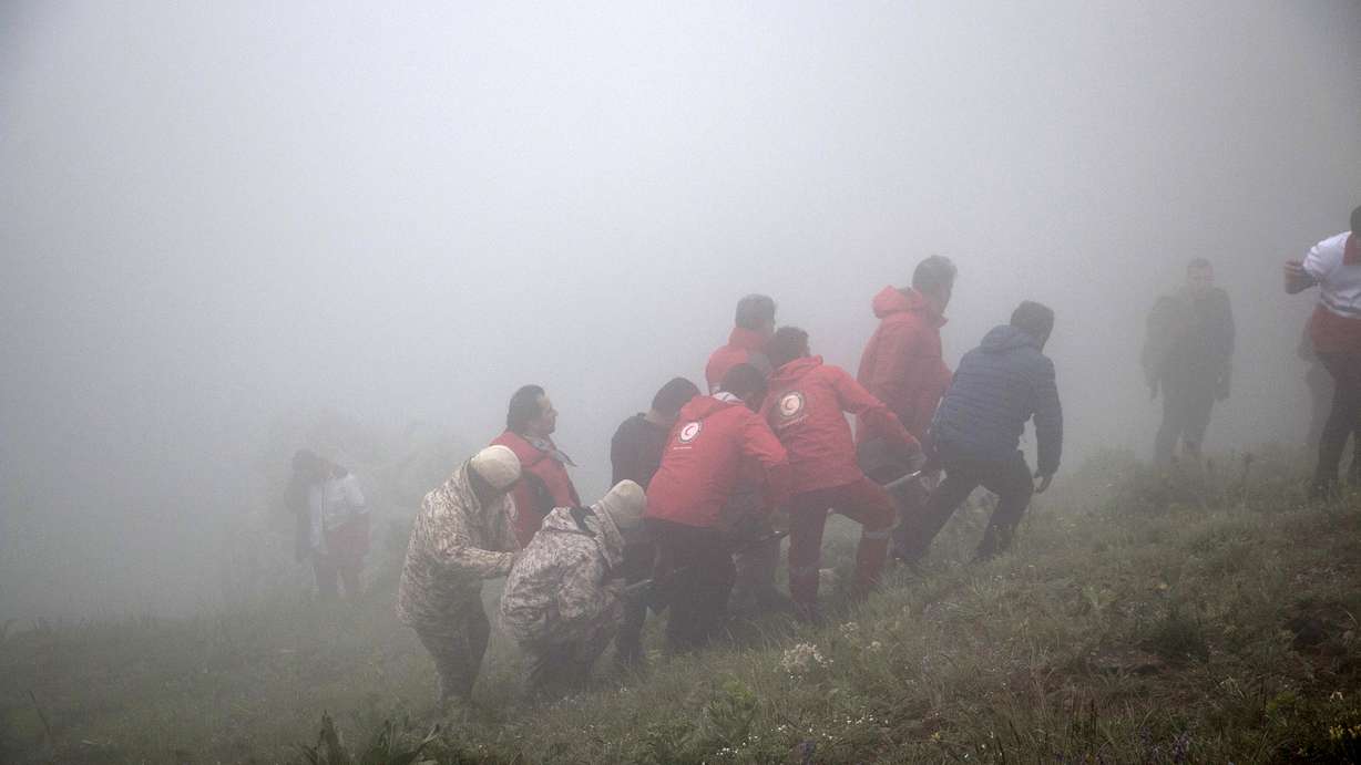 Rescue team members carry the body of a victim after a helicopter carrying Iranian President Ebrahim Raisi crashed in Varzaghan in northwestern Iran, Monday. Raisi, the country’s foreign minister and several other officials were found dead on Monday, hours after their helicopter crashed in a foggy, mountainous region of the country’s northwest, state media reported.