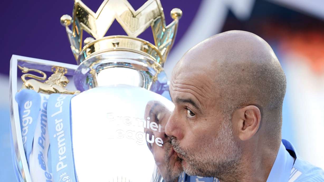 FILE - Manchester City's head coach Pep Guardiola celebrates with the Premier League trophy after the English Premier League soccer match between Manchester City and West Ham United at the Etihad Stadium in Manchester, England, Sunday, May 19, 2024. Manchester City clinched the English Premier League on Sunday after beating West Ham in their last match of the season.