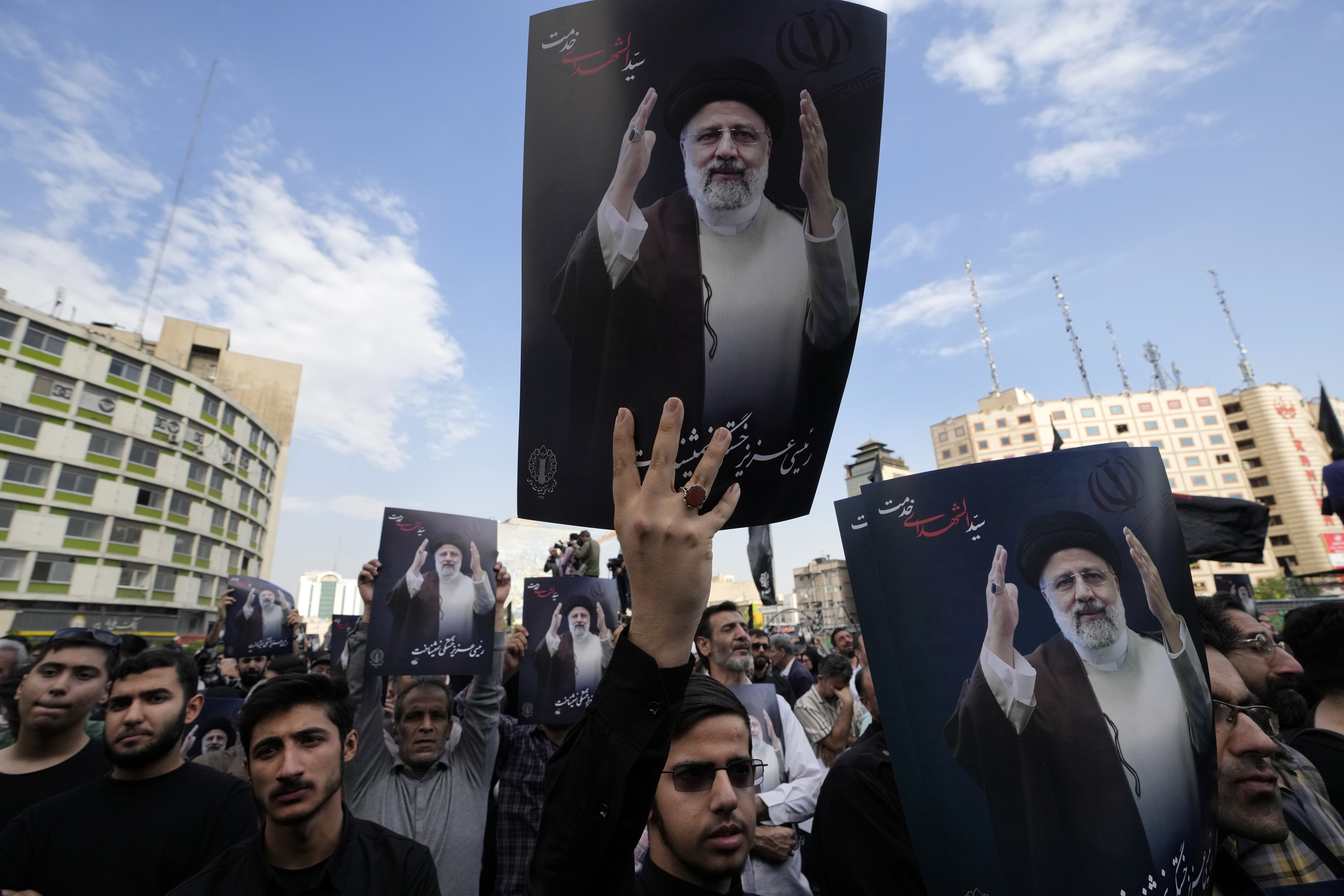 People hold up posters of Iranian President Ebrahim Raisi during a mourning ceremony at Vali-e-Asr square in downtown Tehran, Iran, Monday. Raisi and the country's foreign minister were found dead Monday after their helicopter crashed.