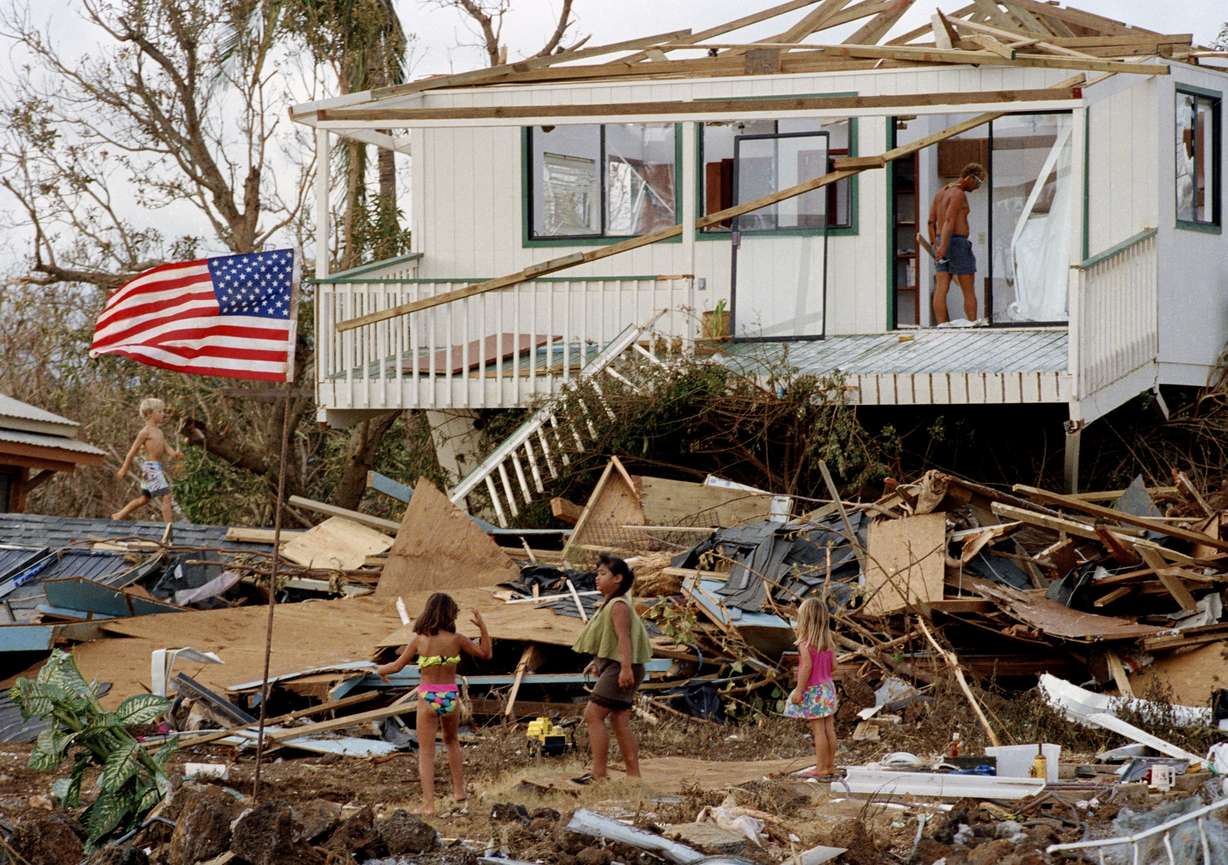 Children play in the rubble left by Hurricane Iniki, Sept. 15, 1992, near Poipu Beach, Kauai, Hawaii. With an El Niño expected to continue to strengthen, forecasters on Thursday predicted a busy Pacific hurricane season.