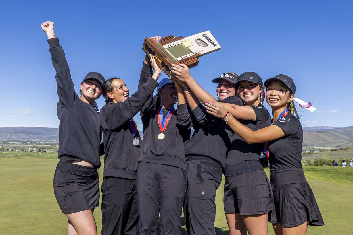 Lone Peak golfers celebrate with the championship trophy after the 6A girls golf high school championship held at Soldier Hollow Golf Course in Midway on Tuesday, May 21, 2024.