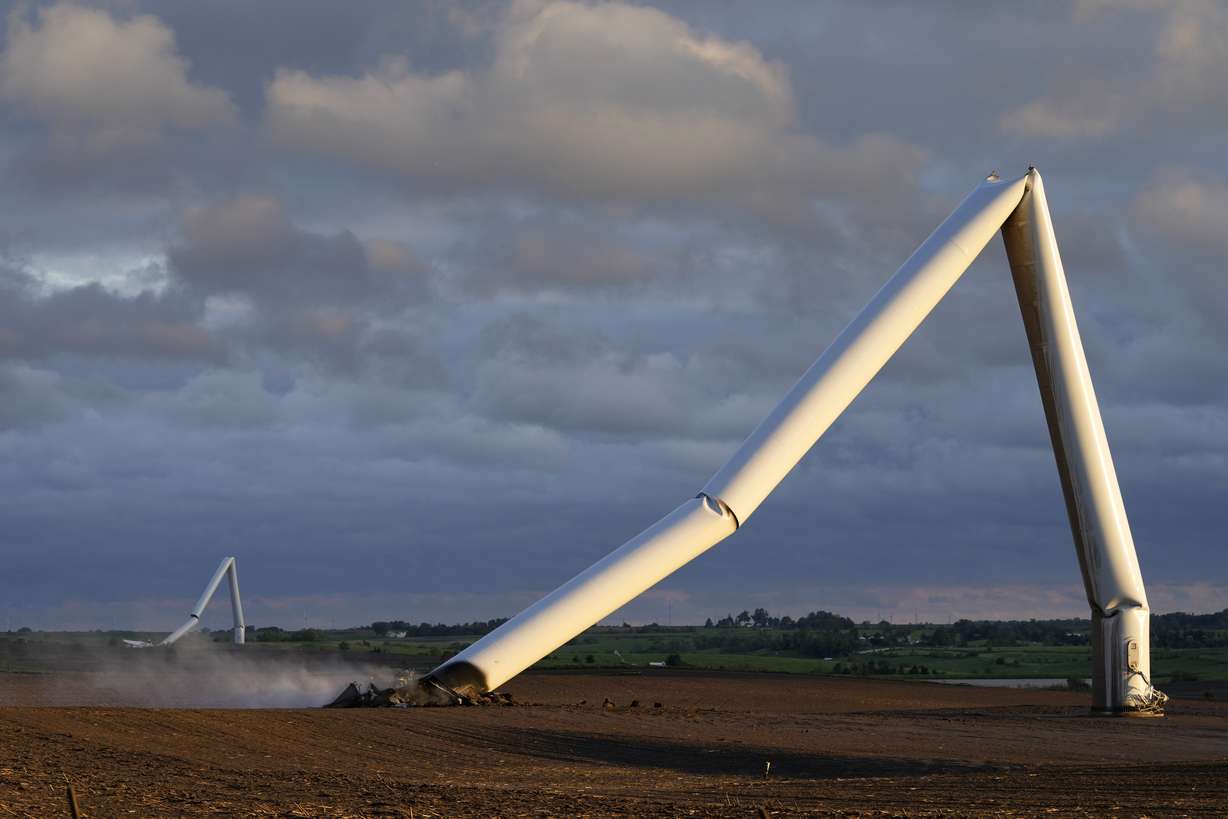 The remains of a tornado-damaged wind turbine touch the ground in a field, Tuesday, near Prescott, Iowa.