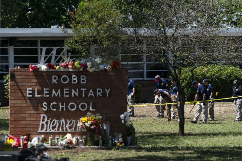 Investigators search for evidence outside Robb Elementary School in Uvalde, Texas, May 25, 2022, following a shooting at the school.
