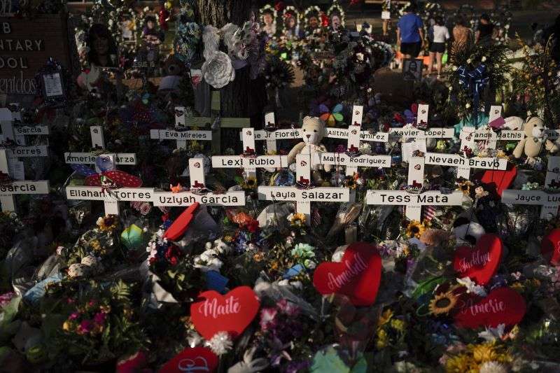 Flowers are piled around crosses with the names of the victims killed in a school shooting as people visit a memorial at Robb Elementary School to pay their respects May 31, 2022, in Uvalde, Texas.