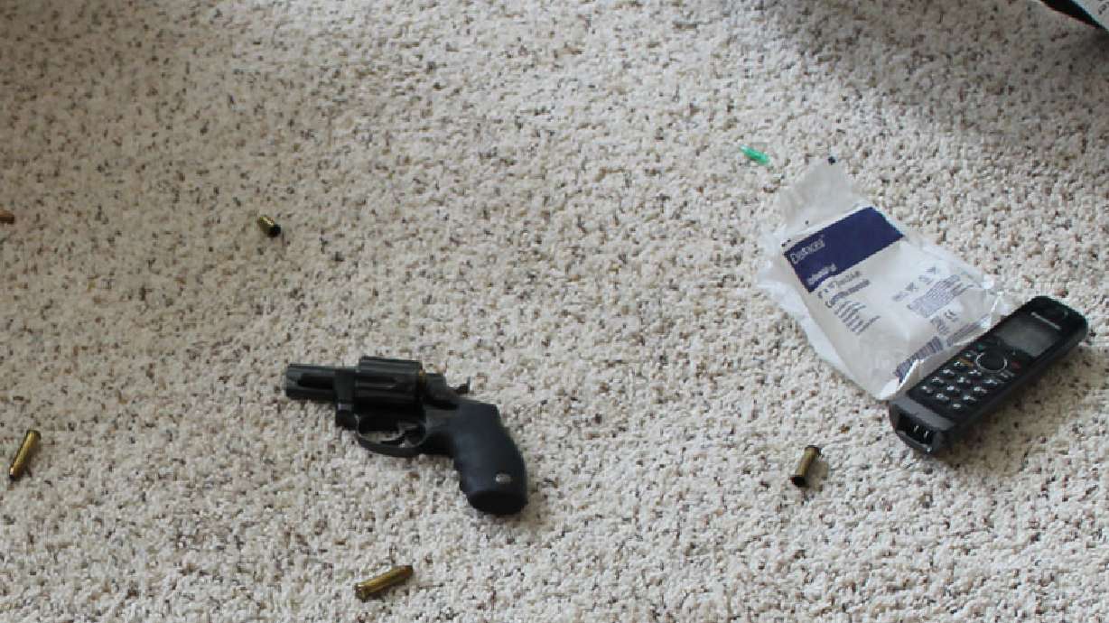 This photo shows the phone used by an Idaho woman to call 911 at the scene of a home invasion in Rose, Idaho on March 13. Next to the phone is her .357 Magnum revolver.