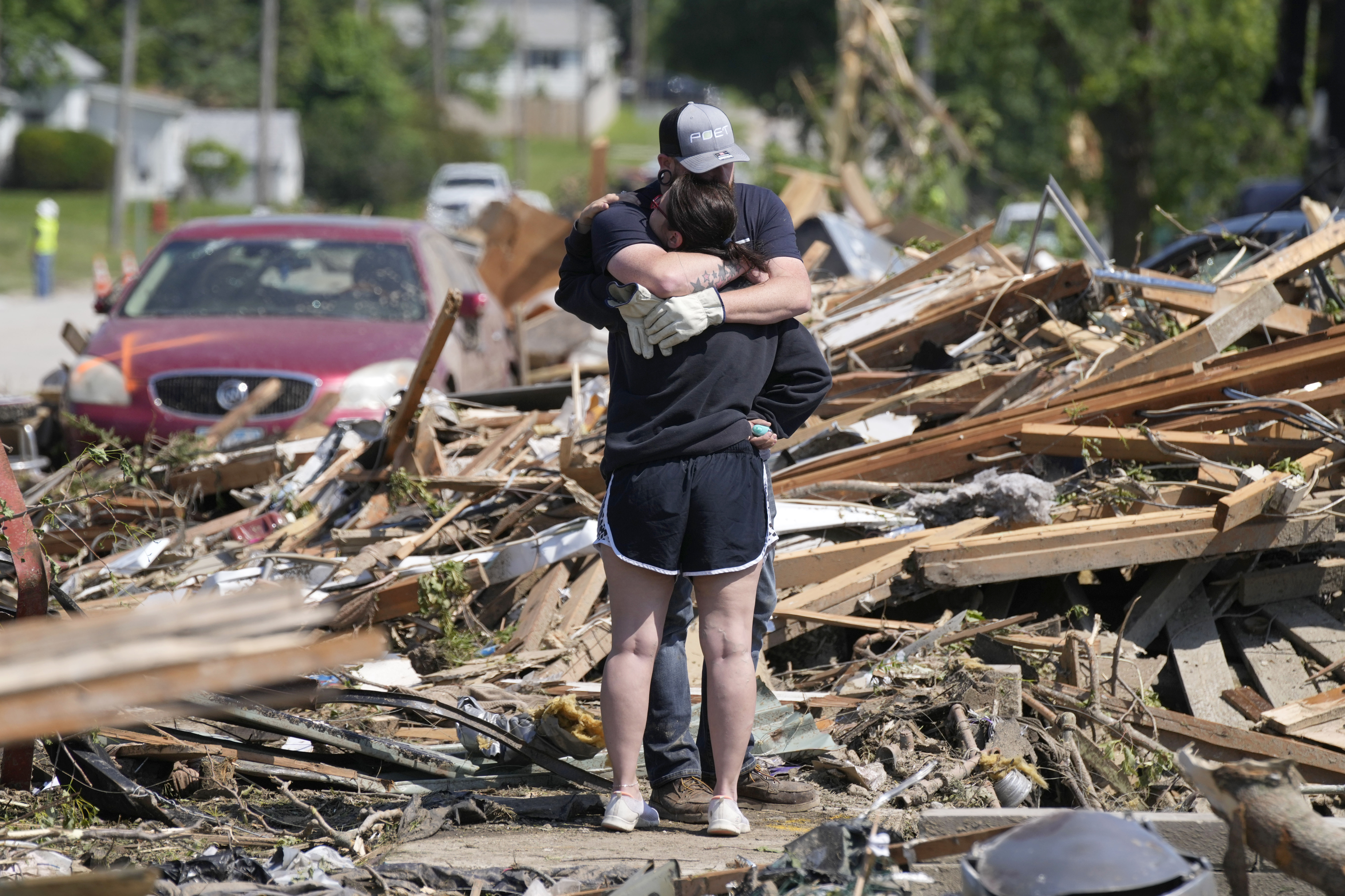 Local residents hug in front of their tornado damaged home, Wednesday, in Greenfield, Iowa.