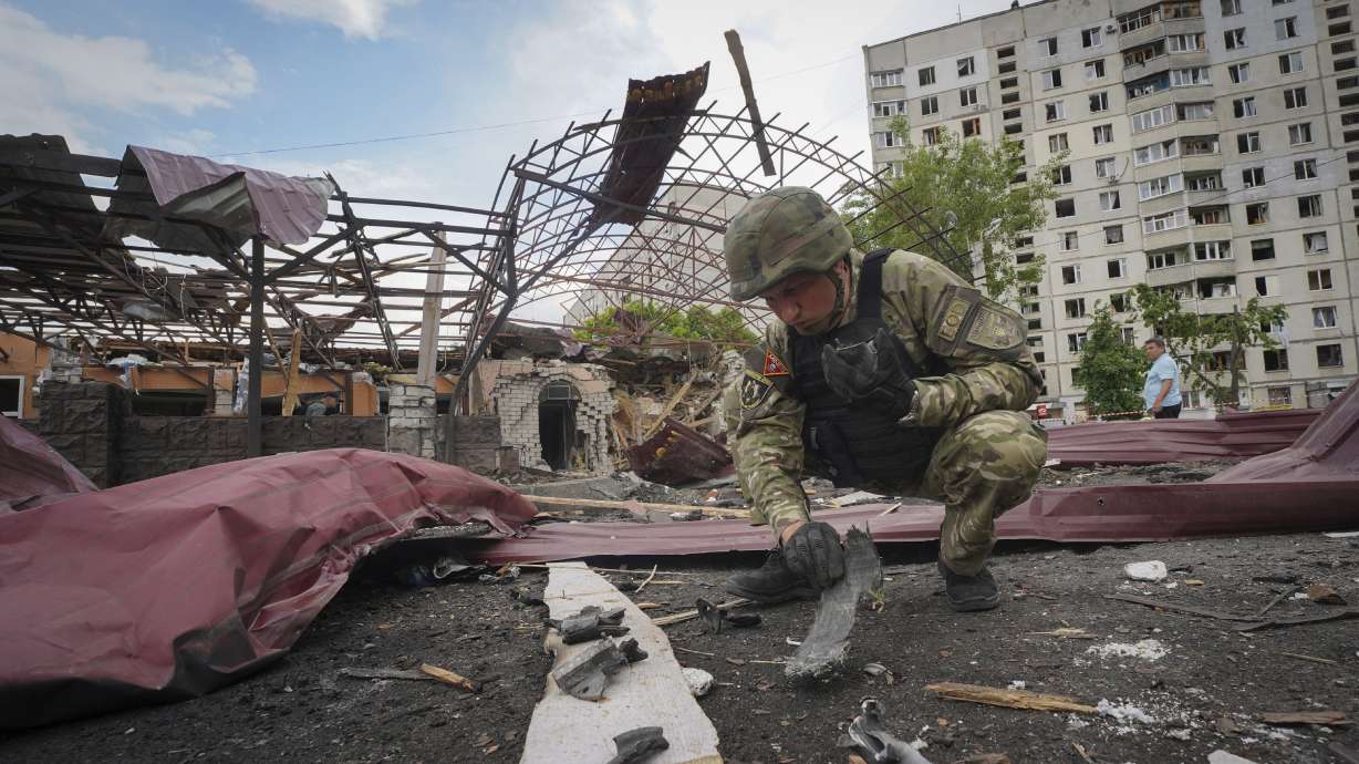 A sapper inspects fragments of a Russian air bomb that hit a living area injuring 10 in Kharkiv, Ukraine, Wednesday.