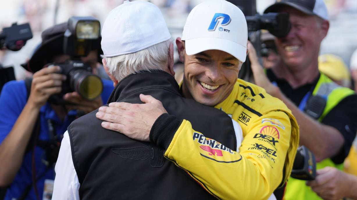 Scott McLaughlin, front right, of New Zealand, celebrates with Roger Penske, front left, after winning the pole for the Indianapolis 500 auto race at Indianapolis Motor Speedway, Sunday, May 19, 2024, in Indianapolis.