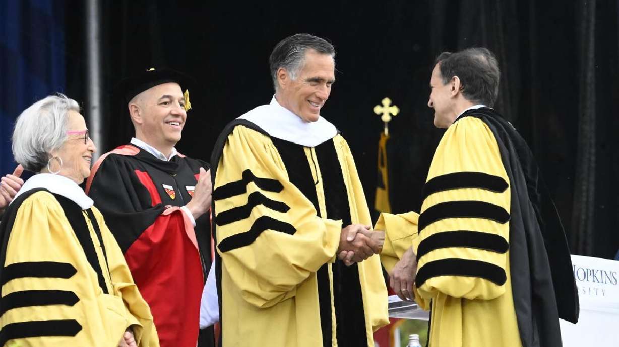 Sen. Mitt Romney, R-Utah, shakes hands with Johns Hopkins University President Ronald Daniels, Thursday. Romney was the university's commencement speaker.