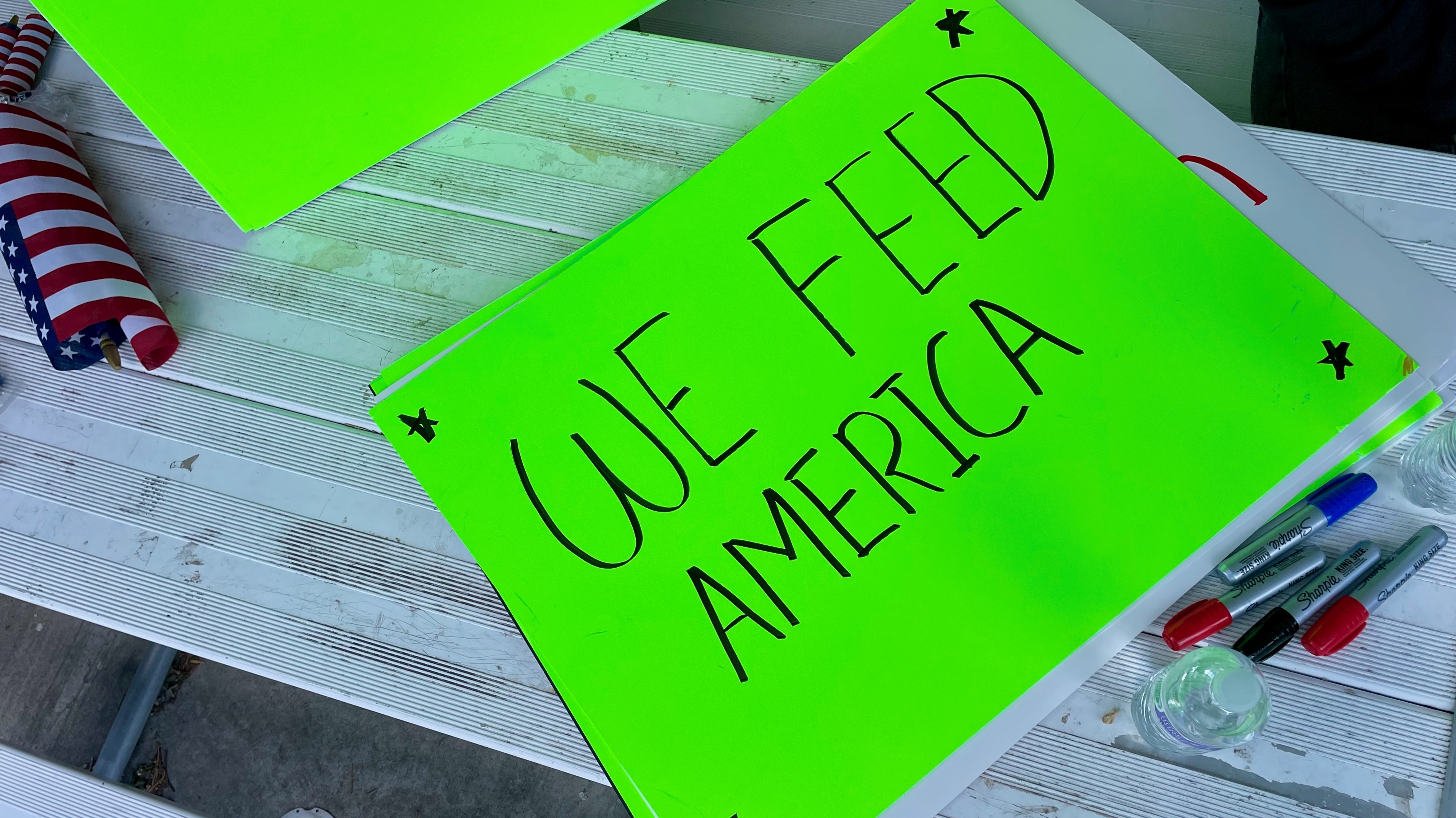 A sign later carried at a demonstration of former Delta Egg Farm workers sits on a picnic table at the Delta City Park on Wednesday.