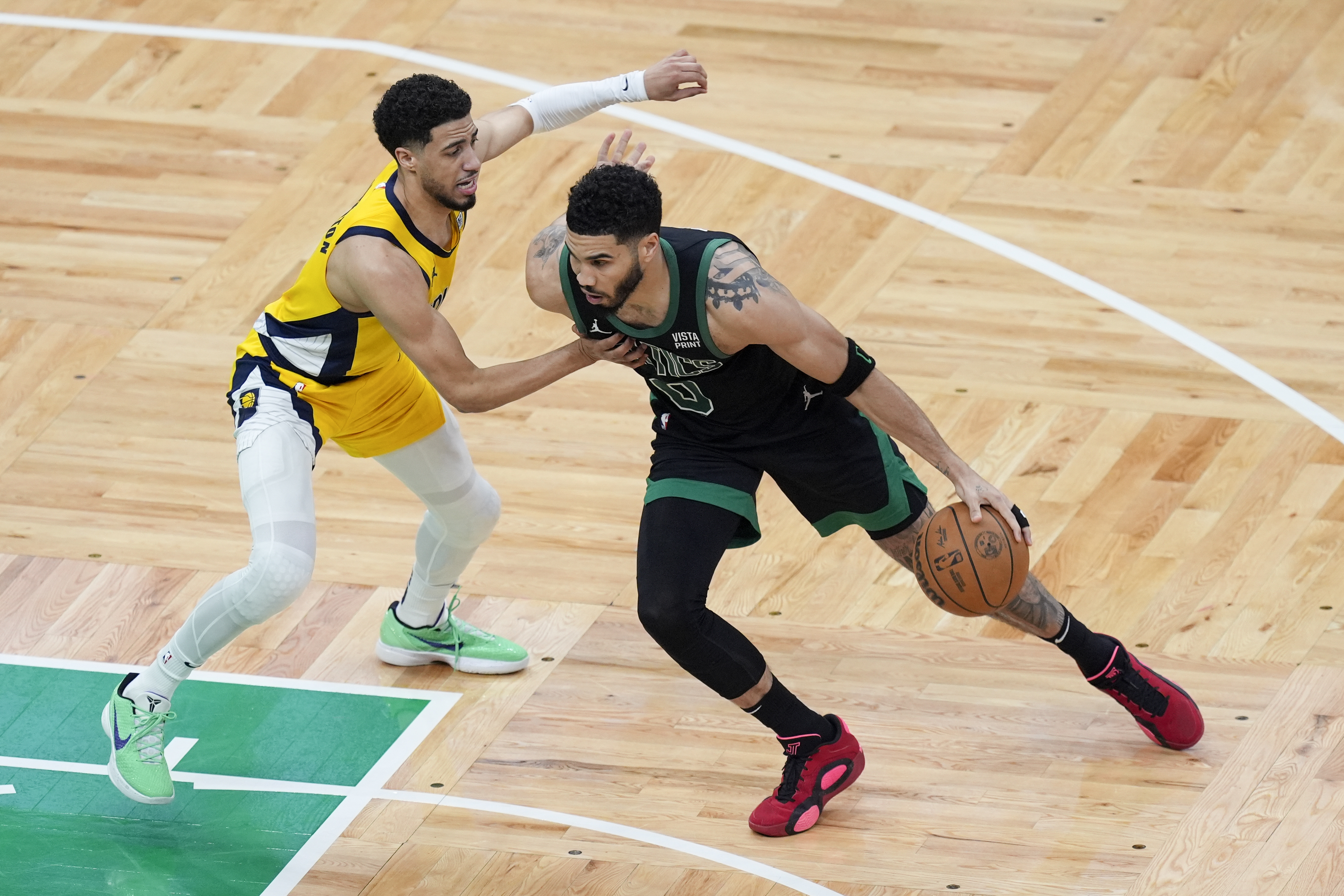 Boston Celtics forward Jayson Tatum (0) is defended by Indiana Pacers guard Tyrese Haliburton, left, during the first half of Game 2 of the NBA Eastern Conference basketball finals Thursday, May 23, 2024, in Boston. 