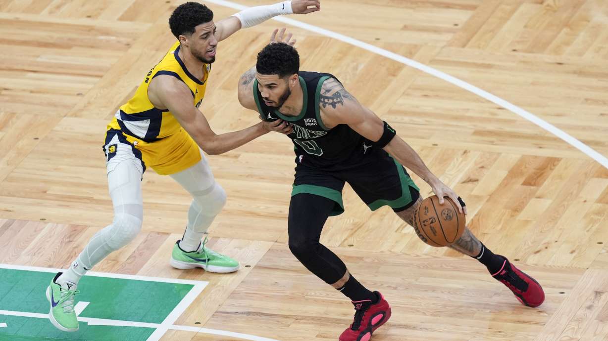 Boston Celtics forward Jayson Tatum (0) is defended by Indiana Pacers guard Tyrese Haliburton, left, during the first half of Game 2 of the NBA Eastern Conference basketball finals Thursday, May 23, 2024, in Boston.