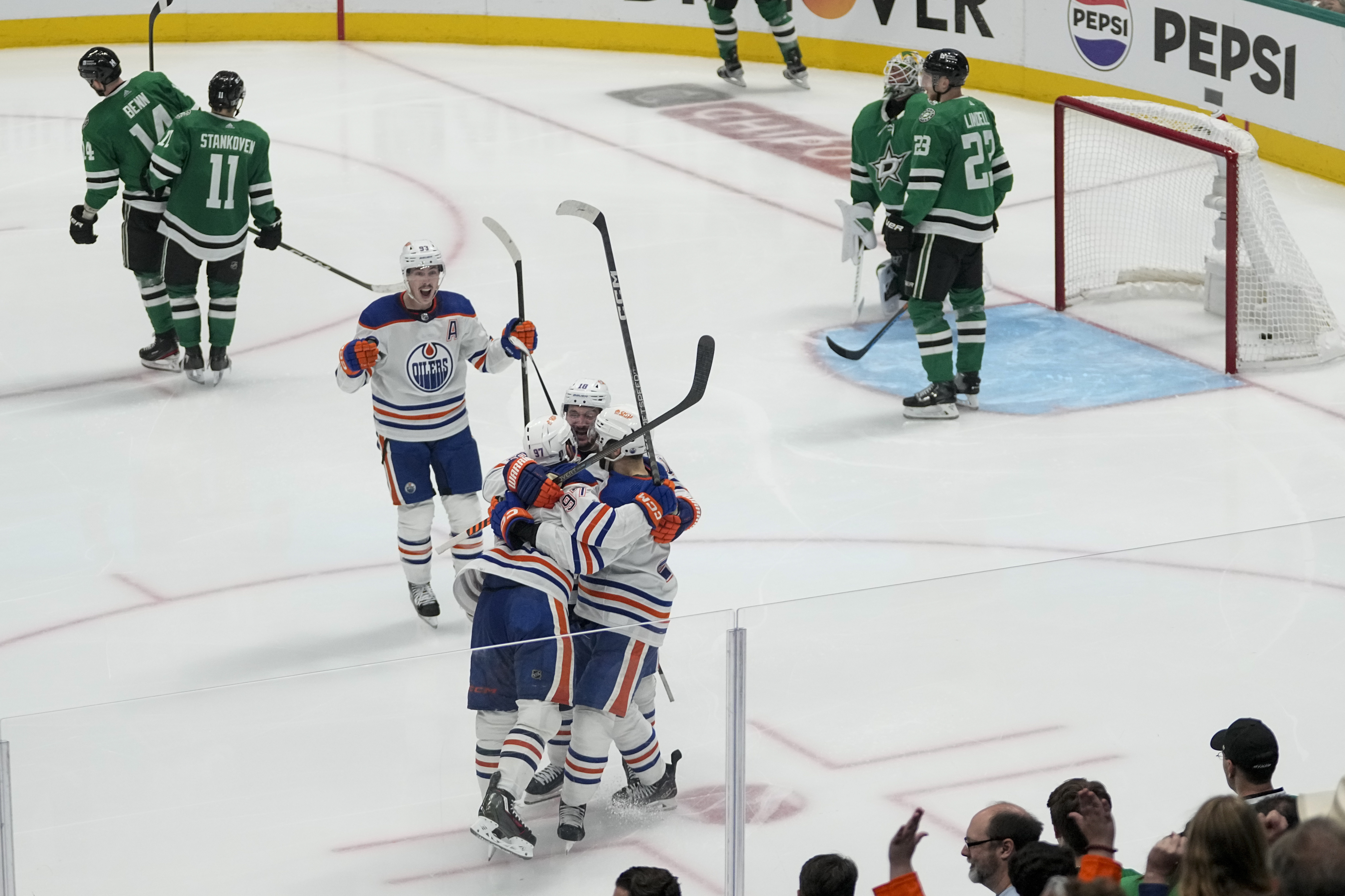 Edmonton Oilers players celebrate a game-winning goal by center Connor McDavid, bottom, left, during the second overtime in Game 1 of the NHL hockey Western Conference Stanley Cup playoff finals against the Dallas Stars, Thursday, May 23, 2024, in Dallas. 