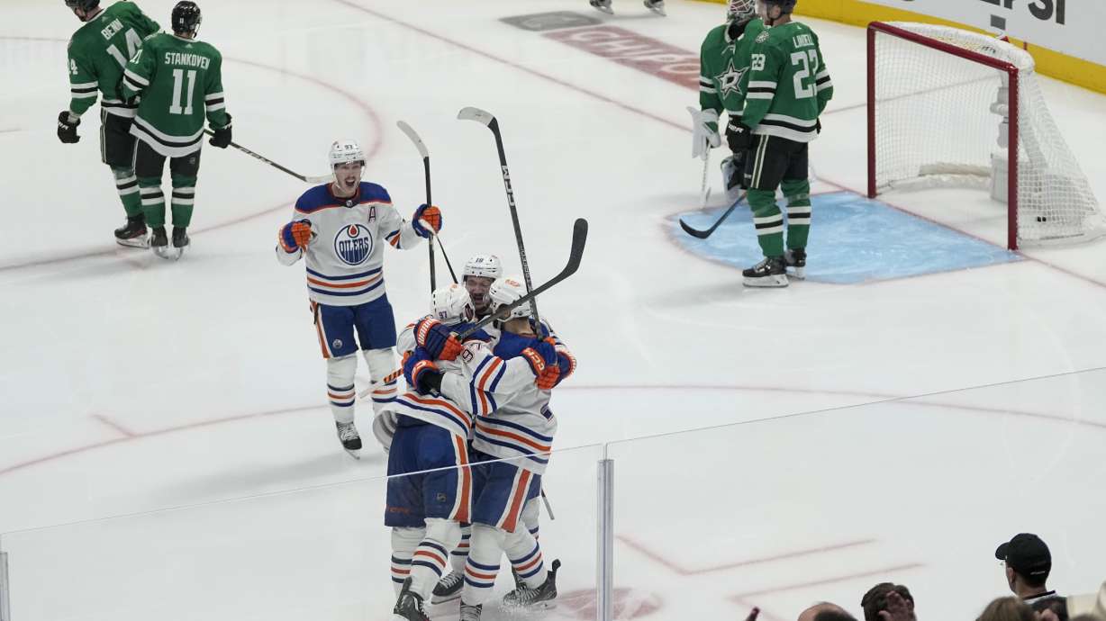 Edmonton Oilers players celebrate a game-winning goal by center Connor McDavid, bottom, left, during the second overtime in Game 1 of the NHL hockey Western Conference Stanley Cup playoff finals against the Dallas Stars, Thursday, May 23, 2024, in Dallas.
