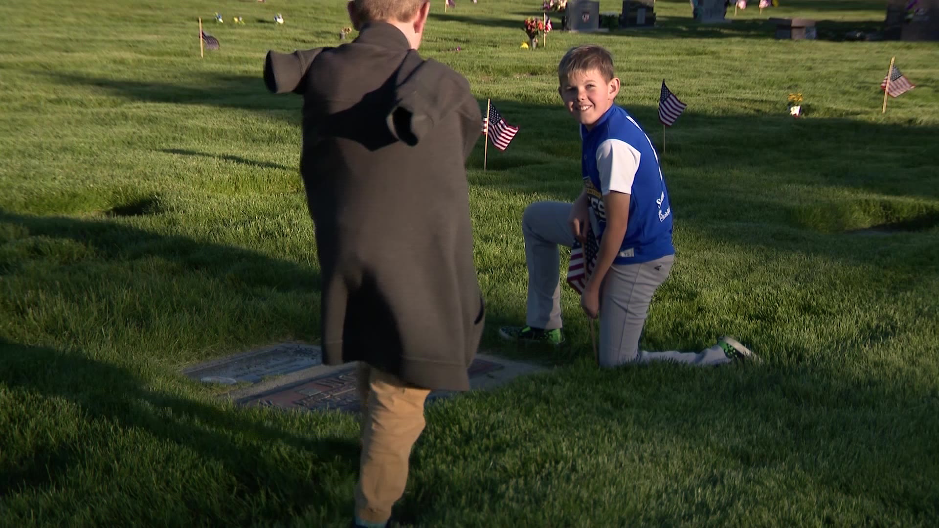 Axel Thomas Peterson placing a flag on a veteran’s grave at Larkin Sunset Gardens Cemetery in Sandy on Thursday.