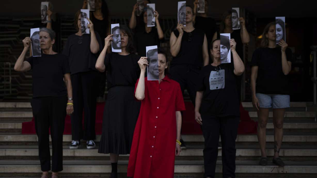 Relatives and supporters of Israeli hostages held by Hamas in Gaza hold photos of their loved ones during a performance calling for their return in Tel Aviv, Israel, Thursday. Israel's army says the bodies of three more hostages killed on Oct. 7, 2023, were recovered overnight from Gaza.