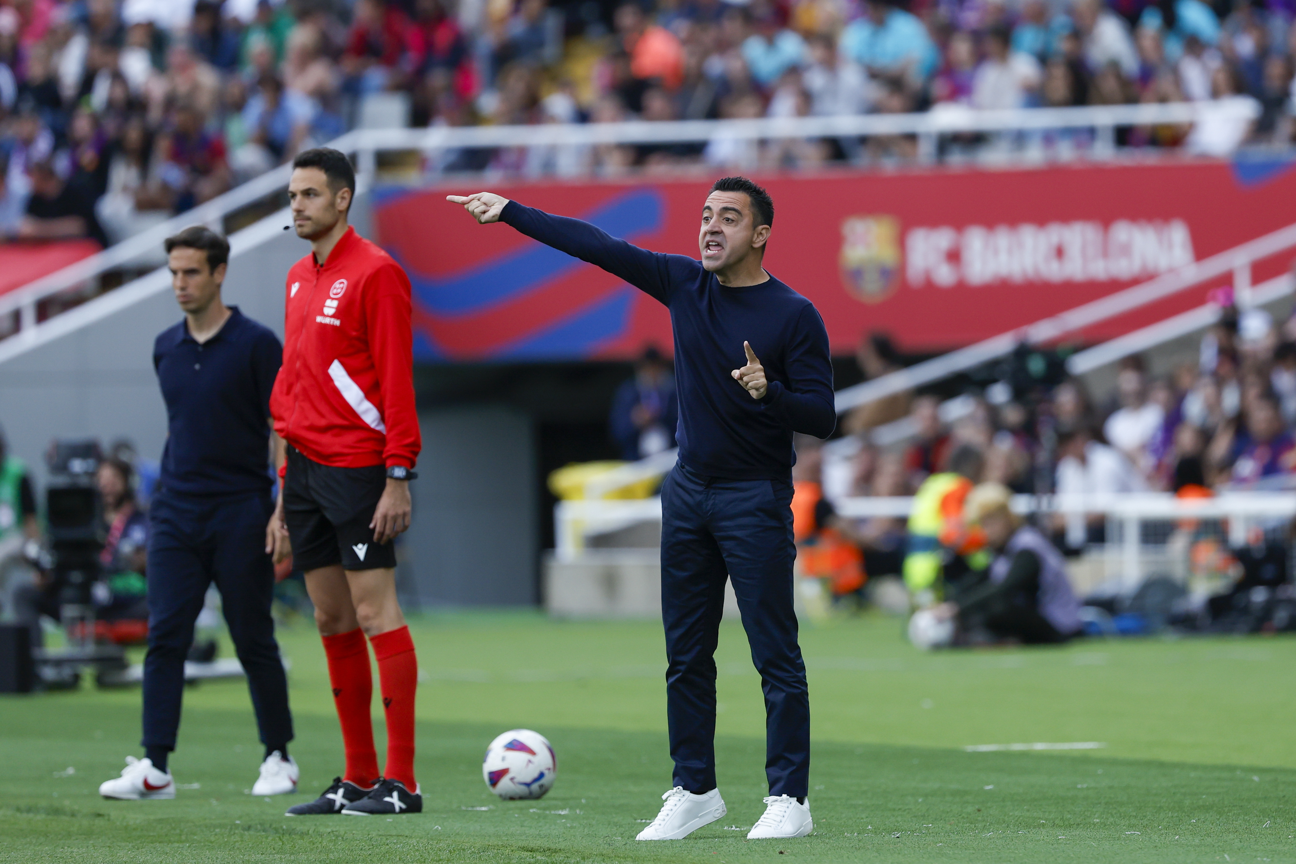 Barcelona's head coach Xavi Hernandez, center, gives instructions during a Spanish La Liga soccer match between Barcelona and Rayo Vallecano at the Olimpic Lluis Companys stadium in Barcelona, Spain, Sunday, May 19, 2024. 