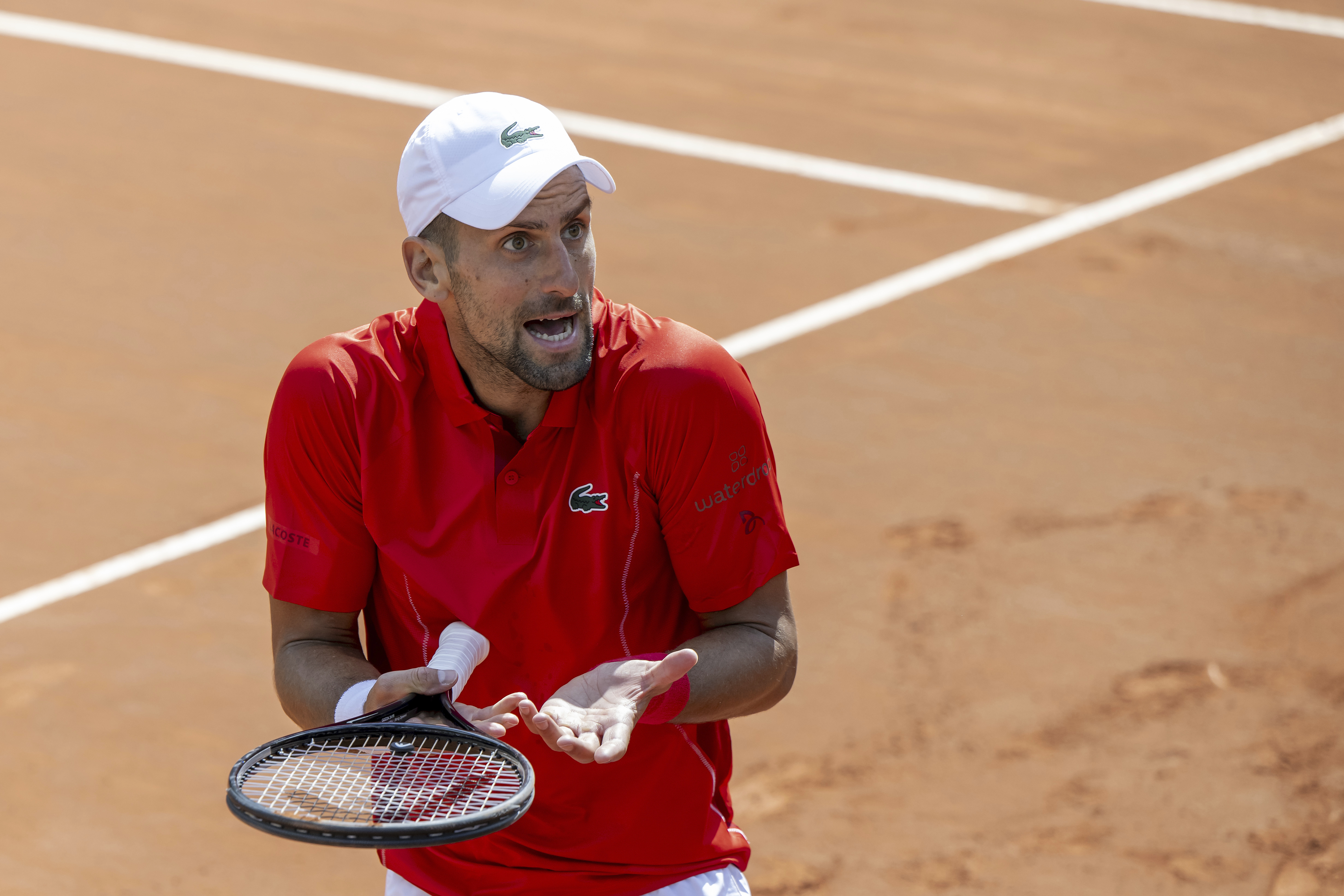 Novak Djokovic, of Serbia, reacts after losing a point as he plays Tomas Machac, of the Czech Republic, during their semi-final match, at the ATP 250 Geneva Open tennis tournament in Geneva, Switzerland, Friday, May 24, 2024.