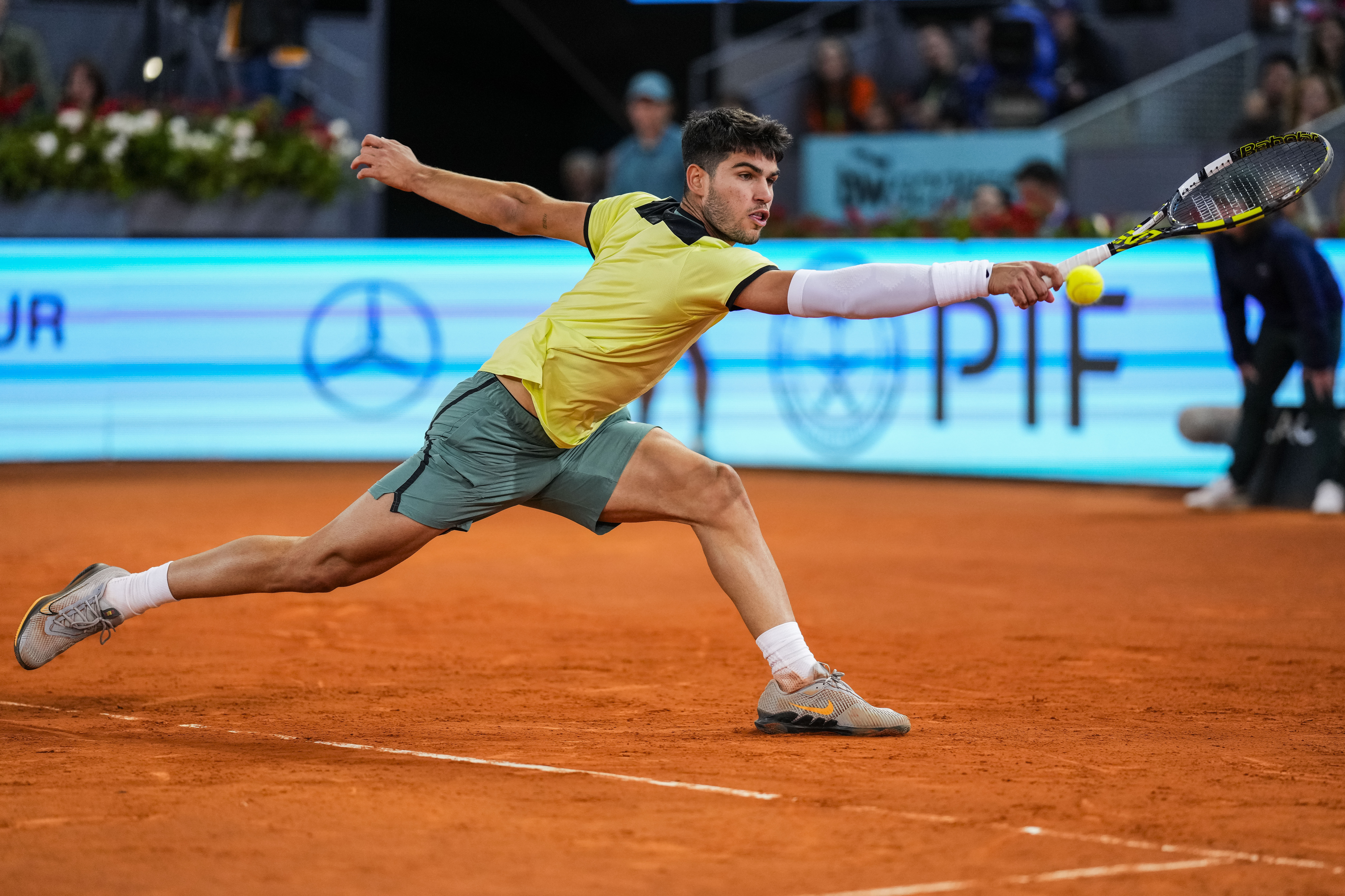 Carlos Alcaraz, of Spain, returns the ball to Andrey Rublev, of Russia, during the Mutua Madrid Open tennis tournament in Madrid, Wednesday, May 1, 2024. 