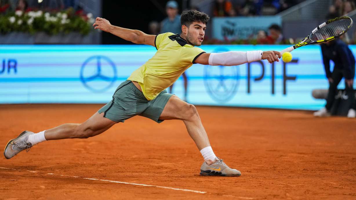 Carlos Alcaraz, of Spain, returns the ball to Andrey Rublev, of Russia, during the Mutua Madrid Open tennis tournament in Madrid, Wednesday, May 1, 2024.