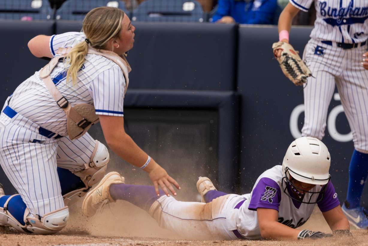 Riverton Silverwolves right fielder Braylee Shields (8) slides into home as Bingham Miners' Rian Howland (21) looks to take her out during the 6A softball state championship at the Miller Park Complex in Provo, on Friday, May 24, 2024.