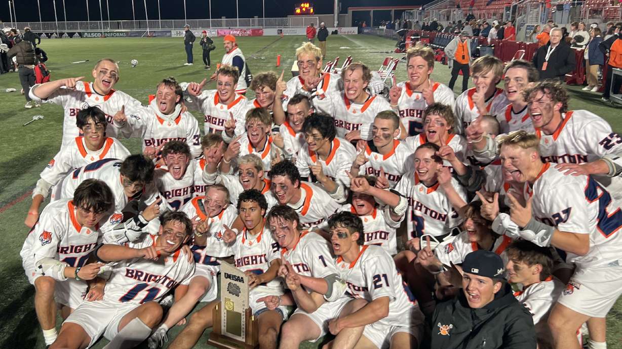 Brighton boys lacrosse celebrates with the 5A state championship trophy.