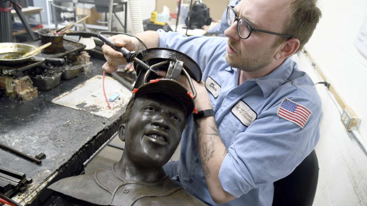 David Hobbs, an employee at Art Castings of Colorado, touches up a wax mold of Jackie Robinson's head in Loveland, Colo. on Wednesday, May 8, 2024. The original statue was cut off at the ankles and stolen from a park in Wichita, Kansas in January. The Colorado foundry cast that sculpture in 2019 and, luckily, still had the original plaster and rubber molds.