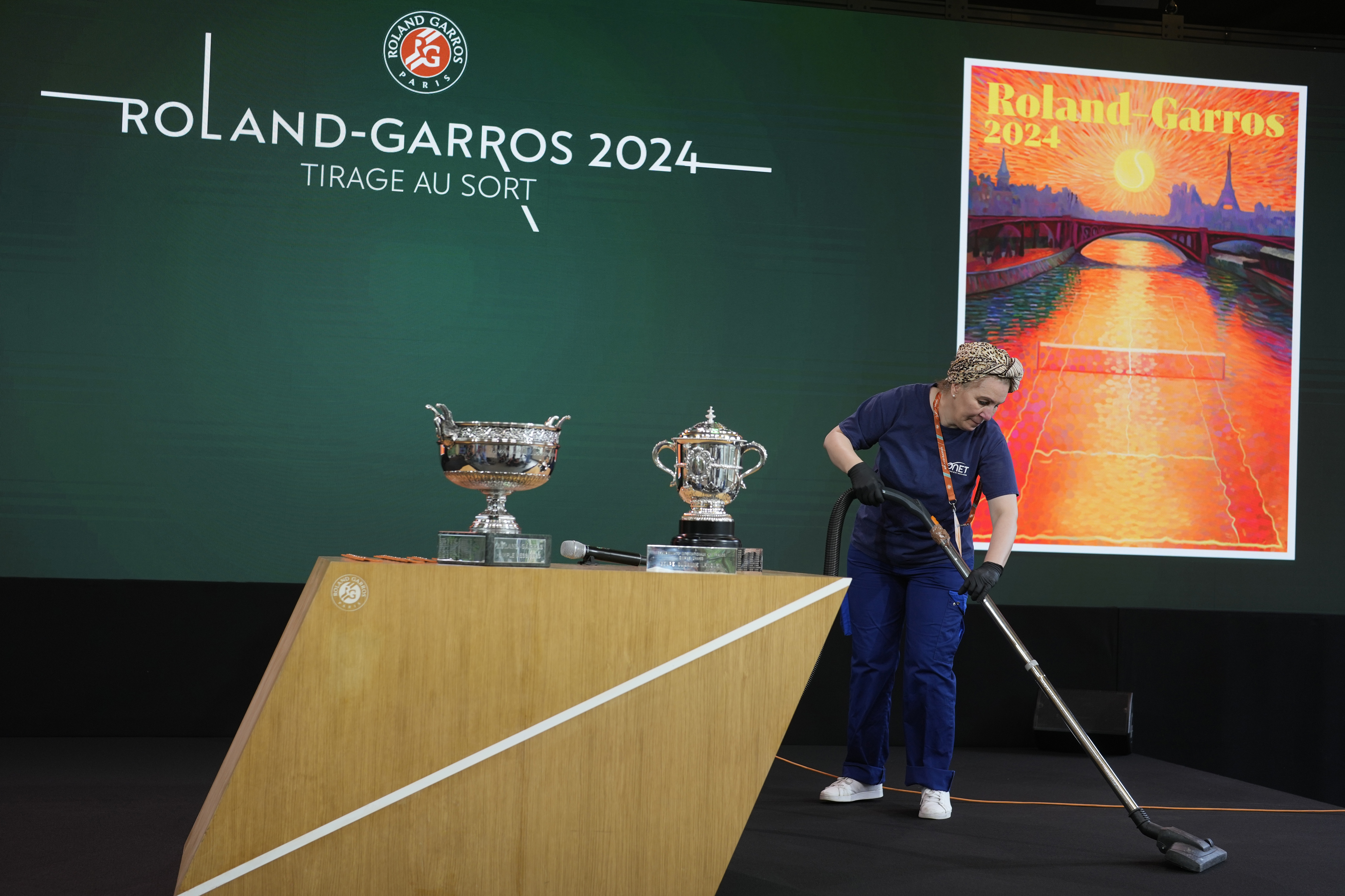 A woman cleans the stage before the draw for the French Tennis Open at the Roland Garros stadium, Thursday, May 23, 2024 in Paris. The tournament starts Sunday May 26, 2024. 