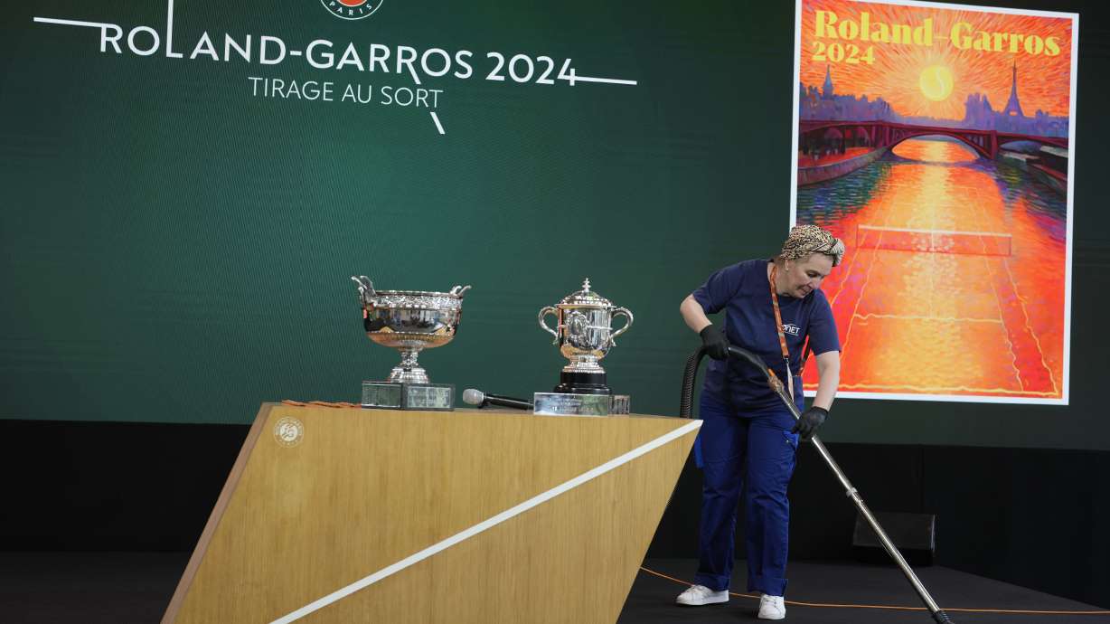A woman cleans the stage before the draw for the French Tennis Open at the Roland Garros stadium, Thursday, May 23, 2024 in Paris. The tournament starts Sunday May 26, 2024.