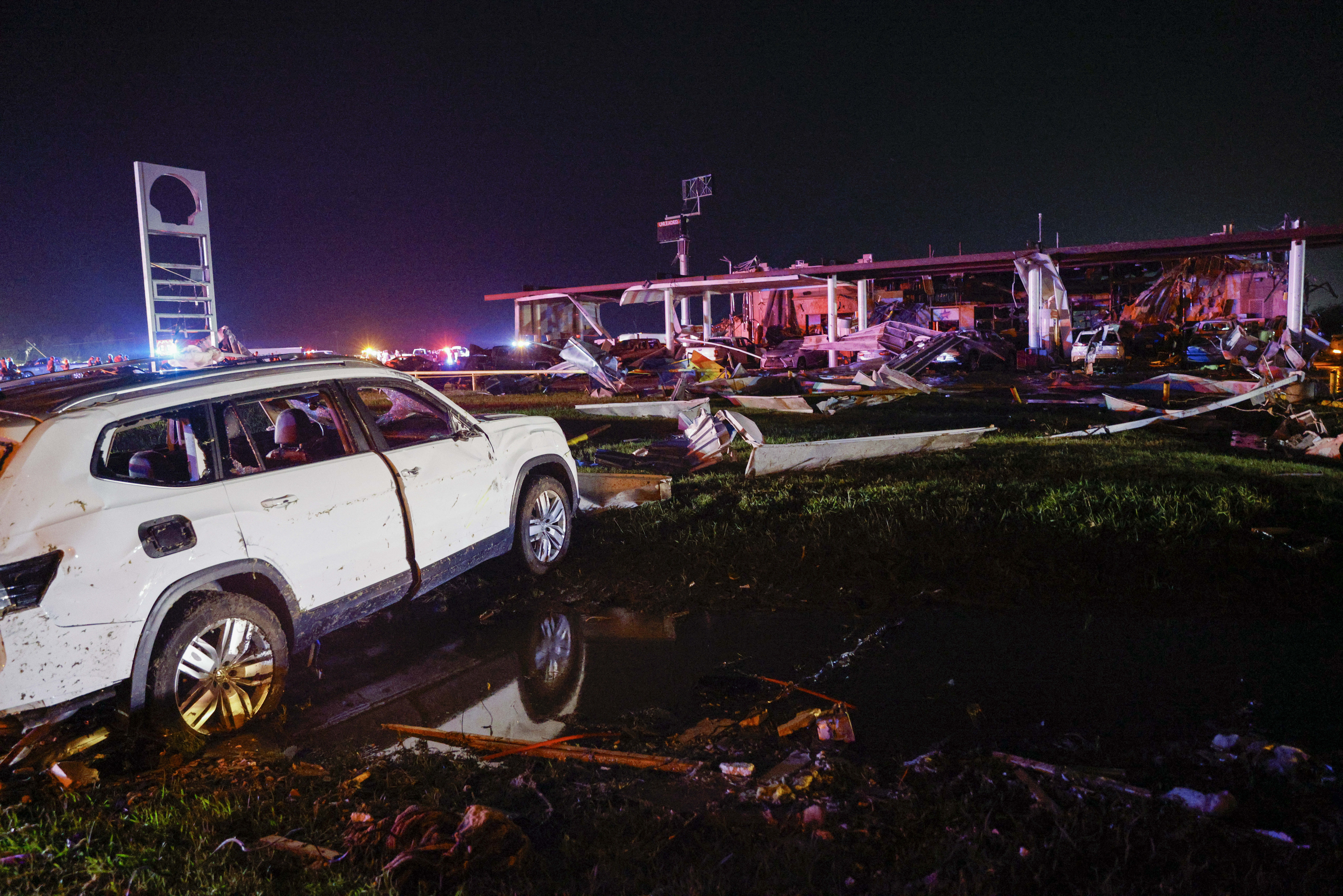A Volkswagen SUV is seen in a ditch near a Shell gas station after a suspected tornado passed through the area Saturday night, Sunday, in Valley View, Texas. Powerful storms killed at least seven people and left a wide trail of destruction Sunday across Texas, Oklahoma and Arkansas after obliterating homes and destroying a truck stop where drivers took shelter during the latest deadly weather to strike the central U.S.