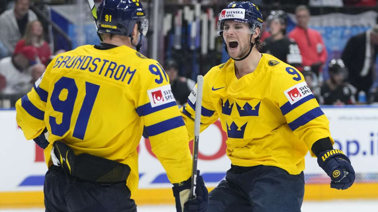 Sweden's Carl Grundstrom, left, celebrates with Sweden's Adrian Kempe after scoring his sides third goal during the bronze medal match between Sweden and Canada at the Ice Hockey World Championships in Prague, Czech Republic, Sunday, May 26, 2024.